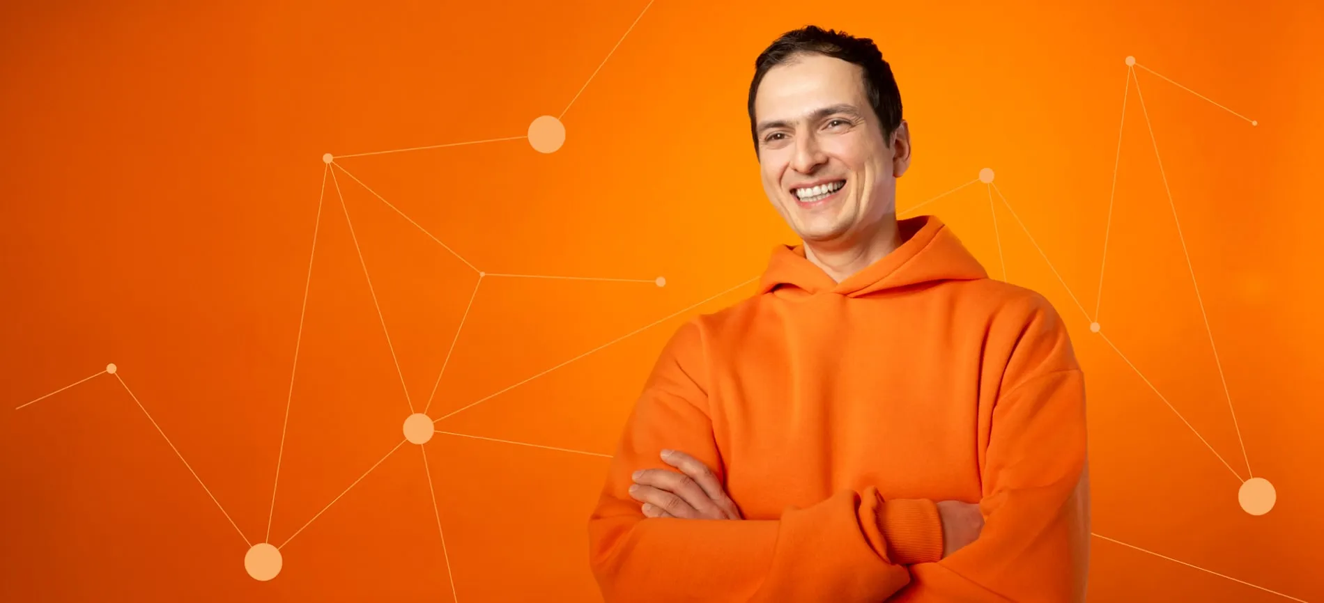 Smiling person in an orange hoodie stands in front of a tech-inspired orange background with connected dots.