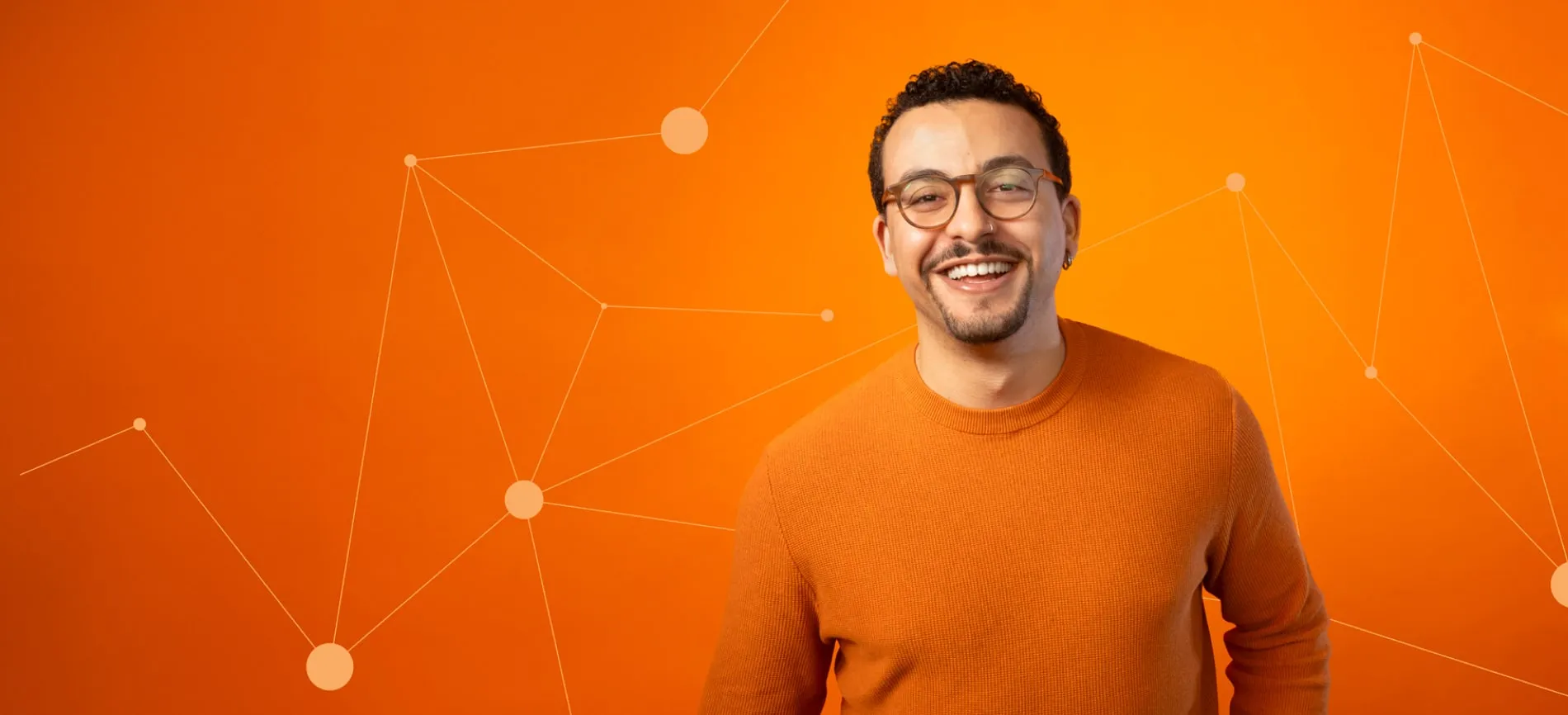Junger Mann mit Brille lächelt vor orangefarbenem Hintergrund mit IT-Netzwerk-Illustration.