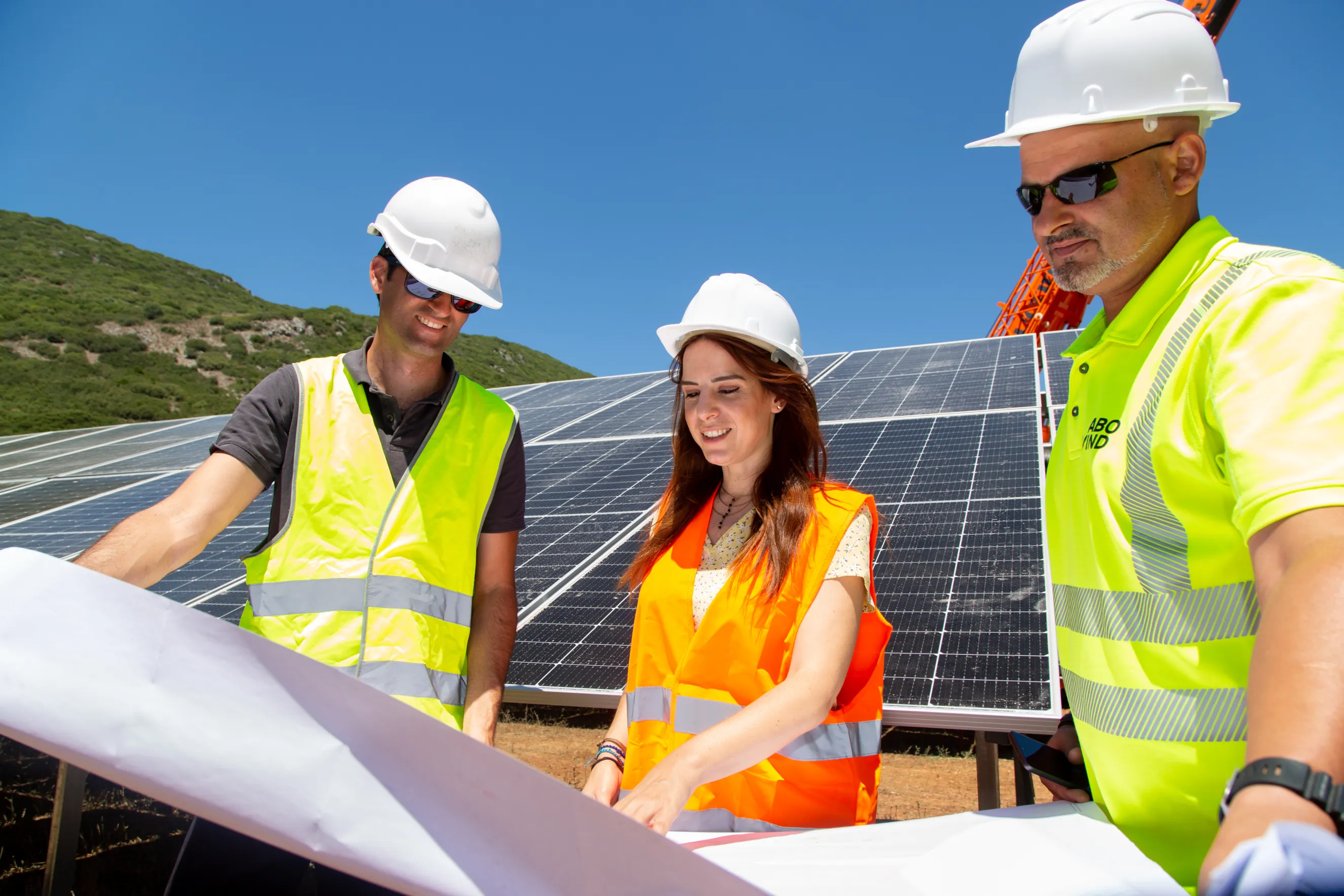 Bauingenieure mit Helm und Westen koordinieren Arbeiten an einem Solarprojekt