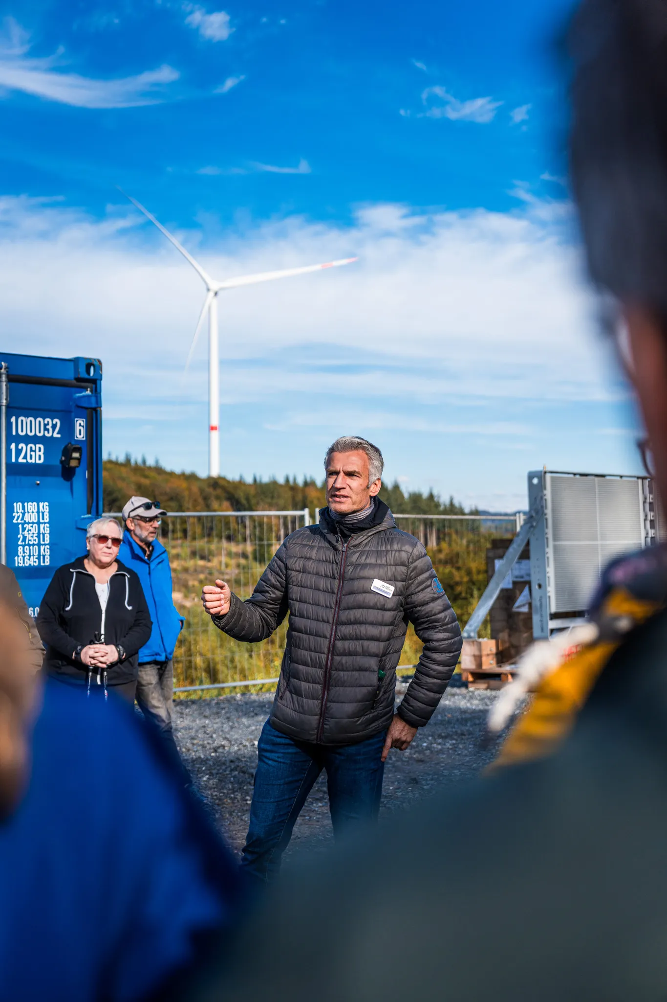 Windkraftanlage von ABO Energy GmbH & Co. KGaA in einer grünen Landschaft mit Fernblick auf Wälder und Felder.