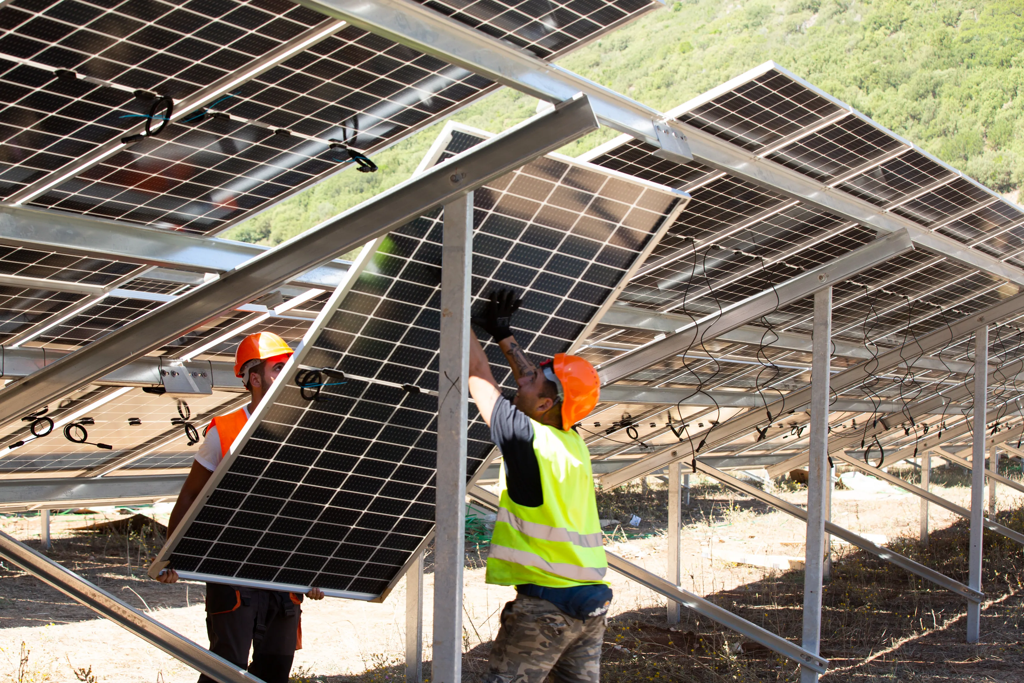 Zwei Arbeiter installieren Solarmodule auf einem Metallgerüst bei ABO Energy GmbH & Co. KGaA.