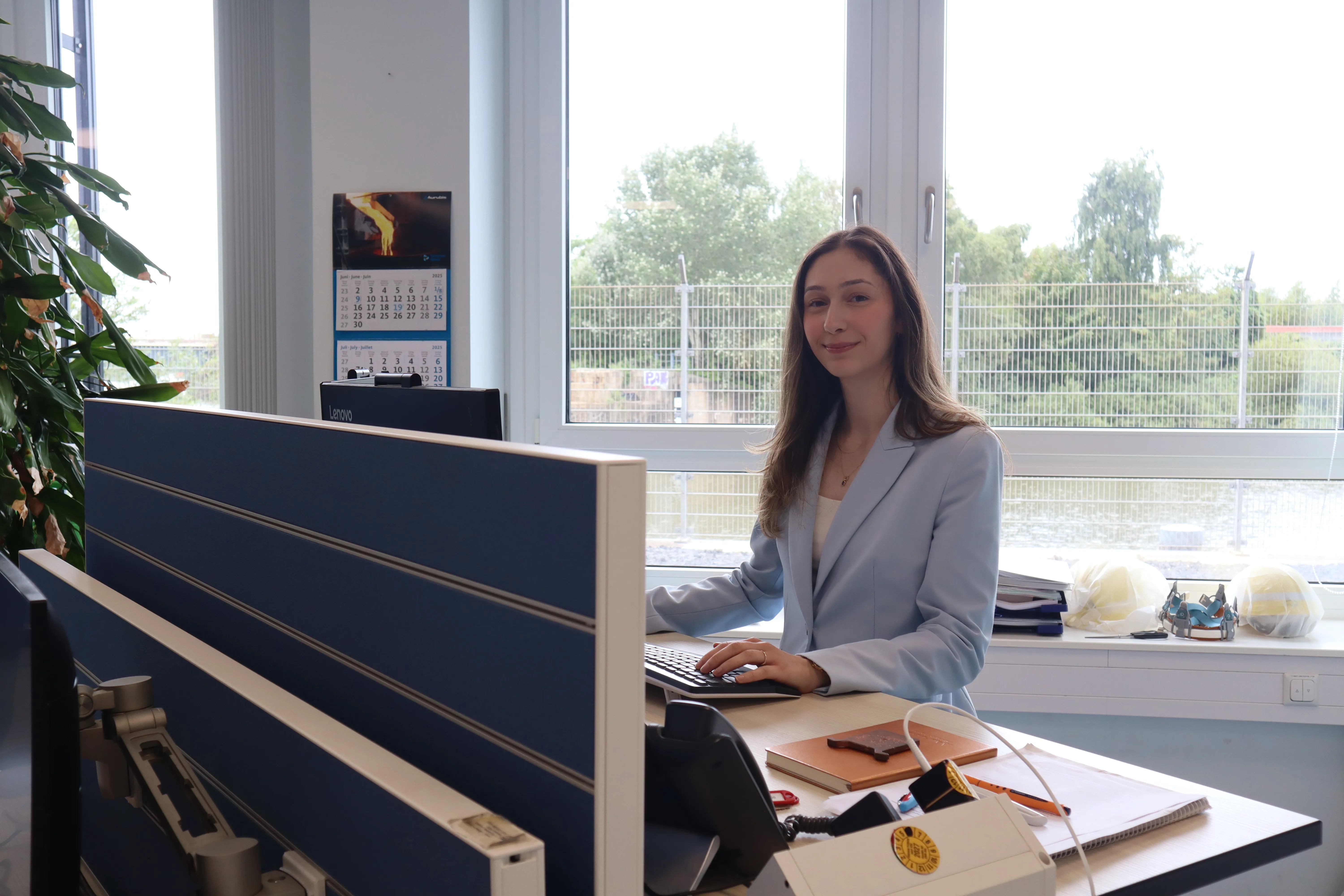 Drei junge Berufseinsteiger führen ein Bewerbungsgespräch bei Aurubis AG im modernen Büro.