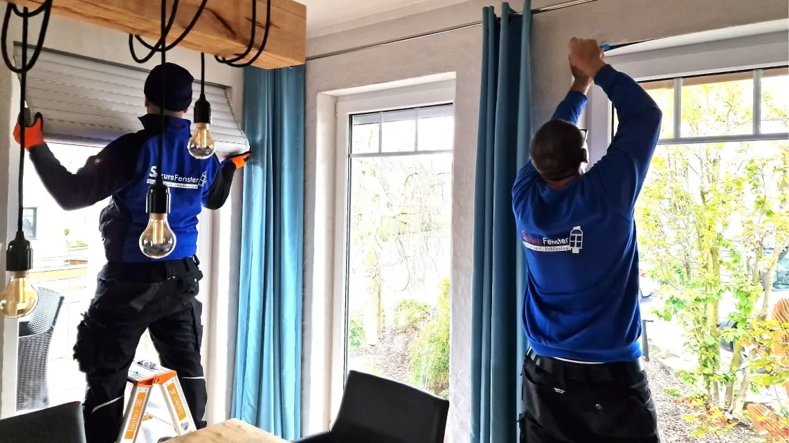 Zwei Monteure installieren Fenster und Rollläden in einem hellen Raum bei bewa-plast Beck GmbH.
