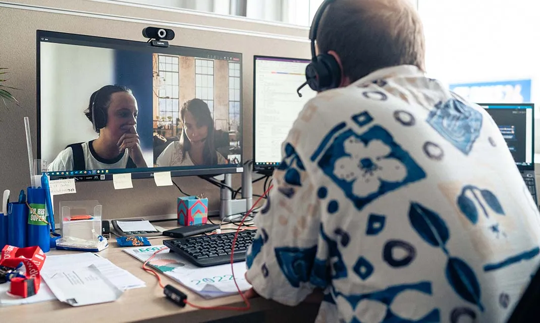 Du nimmst an einem Videomeeting mit Kolleg:innen bei Bike24 teil und arbeitest flexibel im Büro.