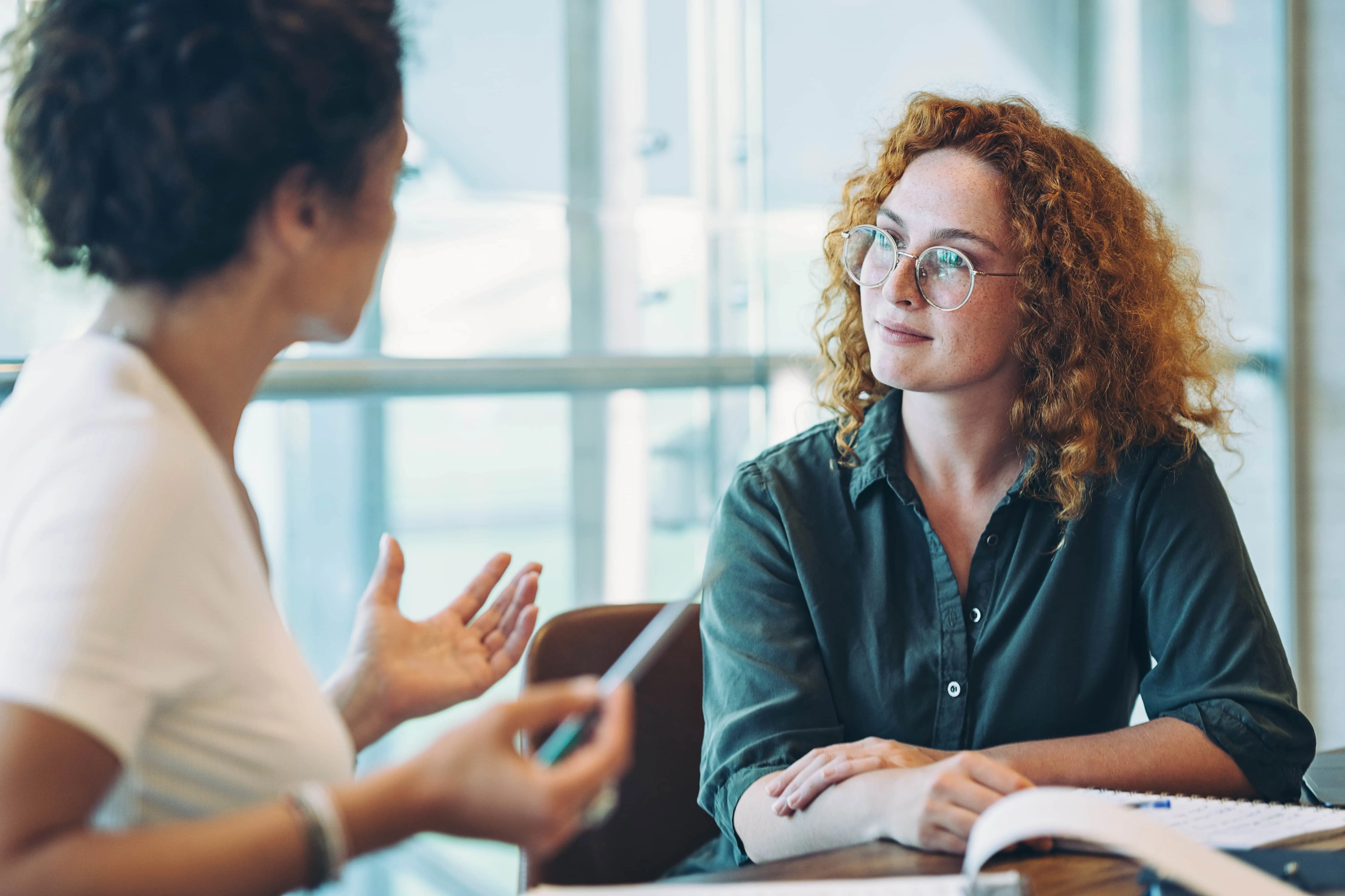 Zwei Frauen im Gespräch bei BKK Linde; Du erhältst persönliche Beratung zu Karrieremöglichkeiten im Gesundheitswesen. (iStock / pixelfit)