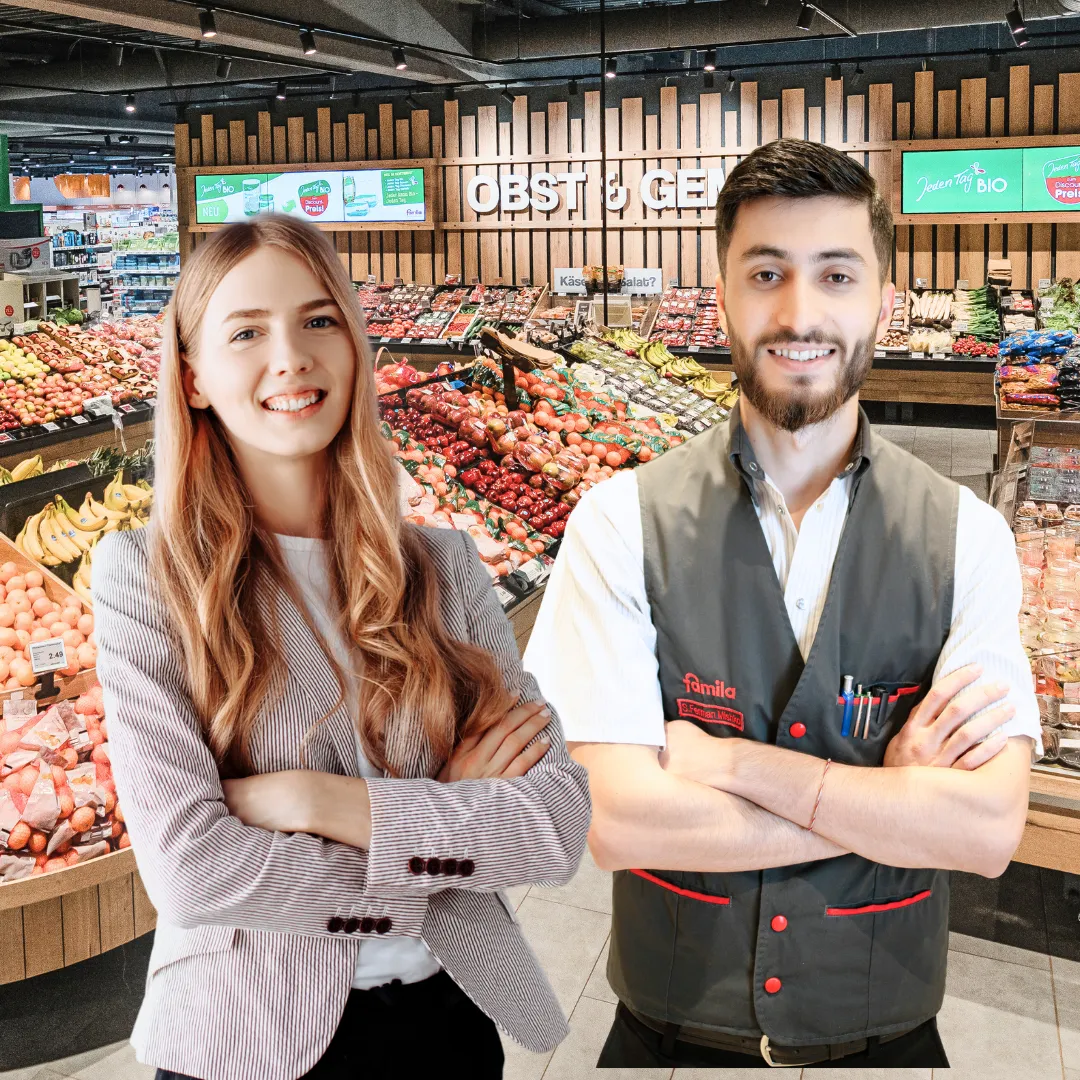 Mitarbeiter in einem modernen Supermarkt von Bünting Unternehmensgruppe vor einem Regal mit frischem Obst und Gemüse.