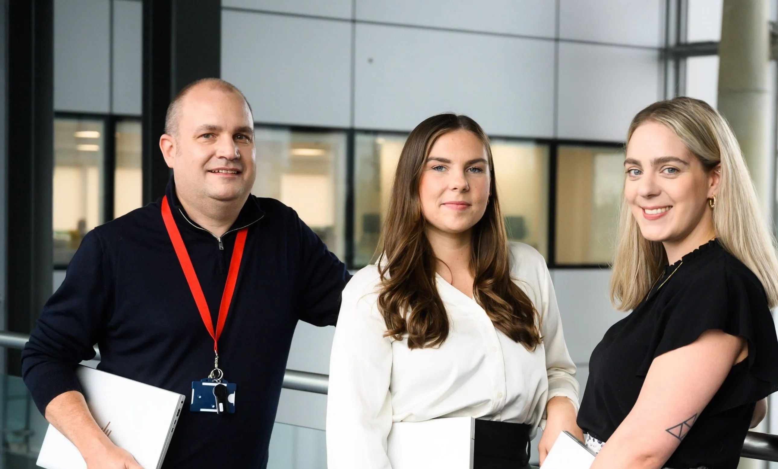 A group of four people gathered in an office building, showcasing teamwork and professional interaction