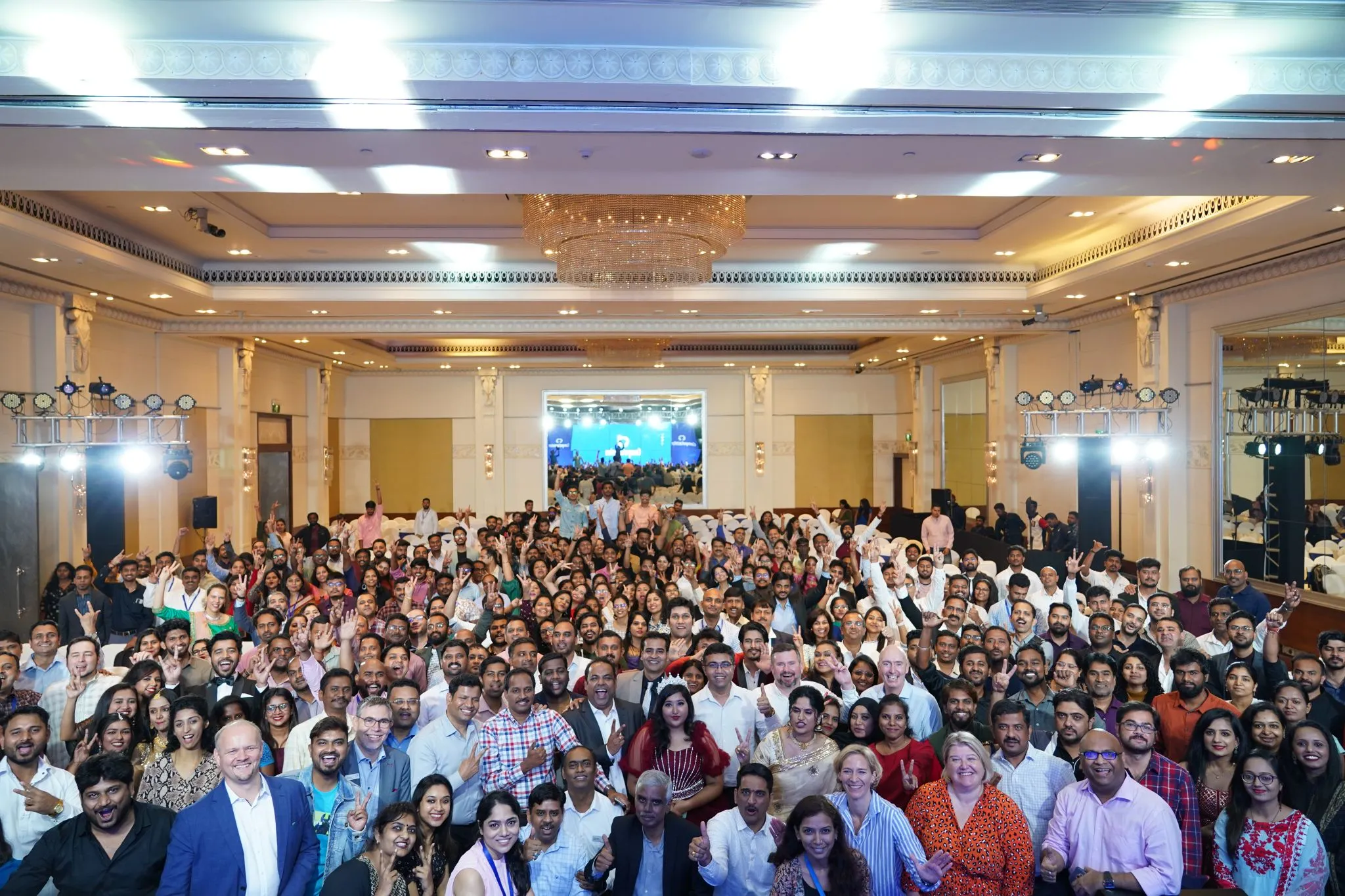 A lively group of Computacenter employees celebrating together at a company event in a grand hall.