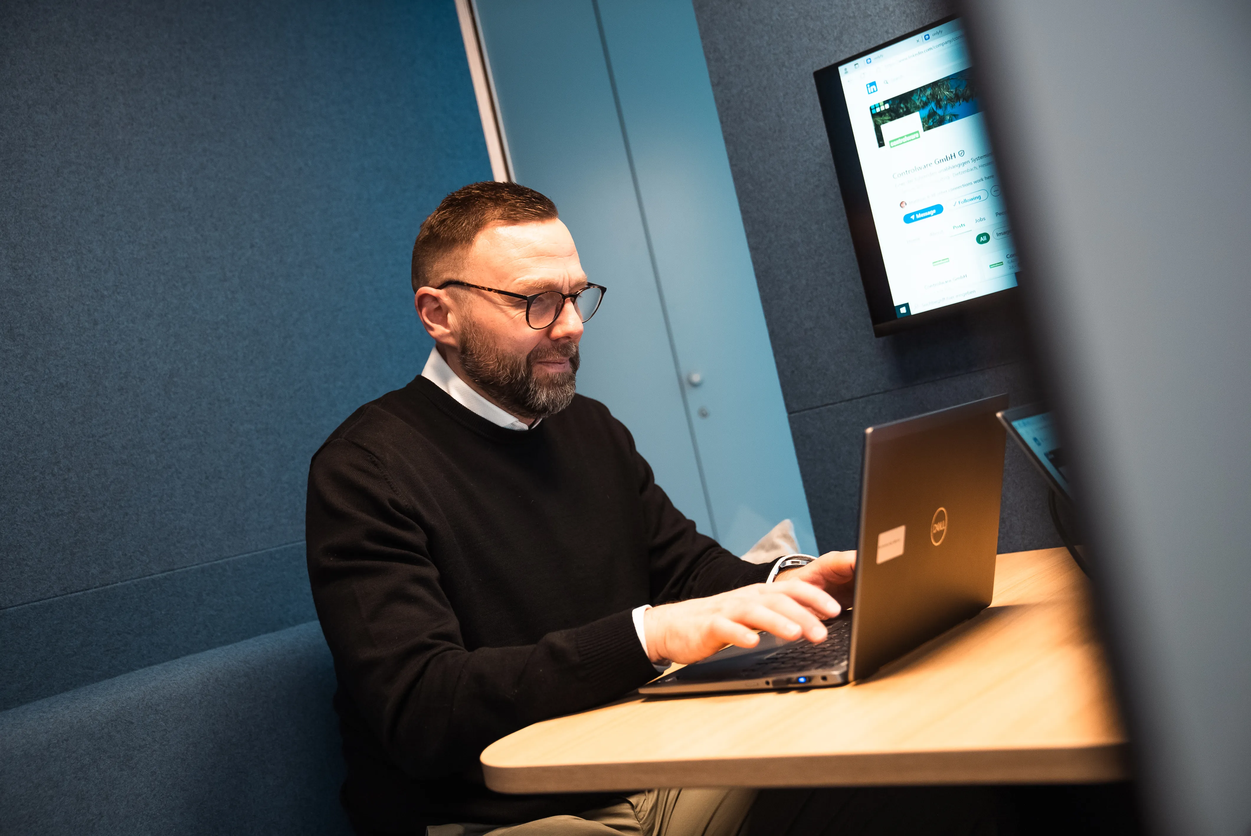 Zwei Personen arbeiten gemeinsam an Laptops in einem modernen Meetingraum und besprechen Karrieremöglichkeiten.