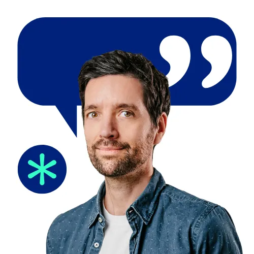 Smiling team member in a casual shirt with a chat bubble and asterisk, highlighting open communication at collaboration Factory AG.