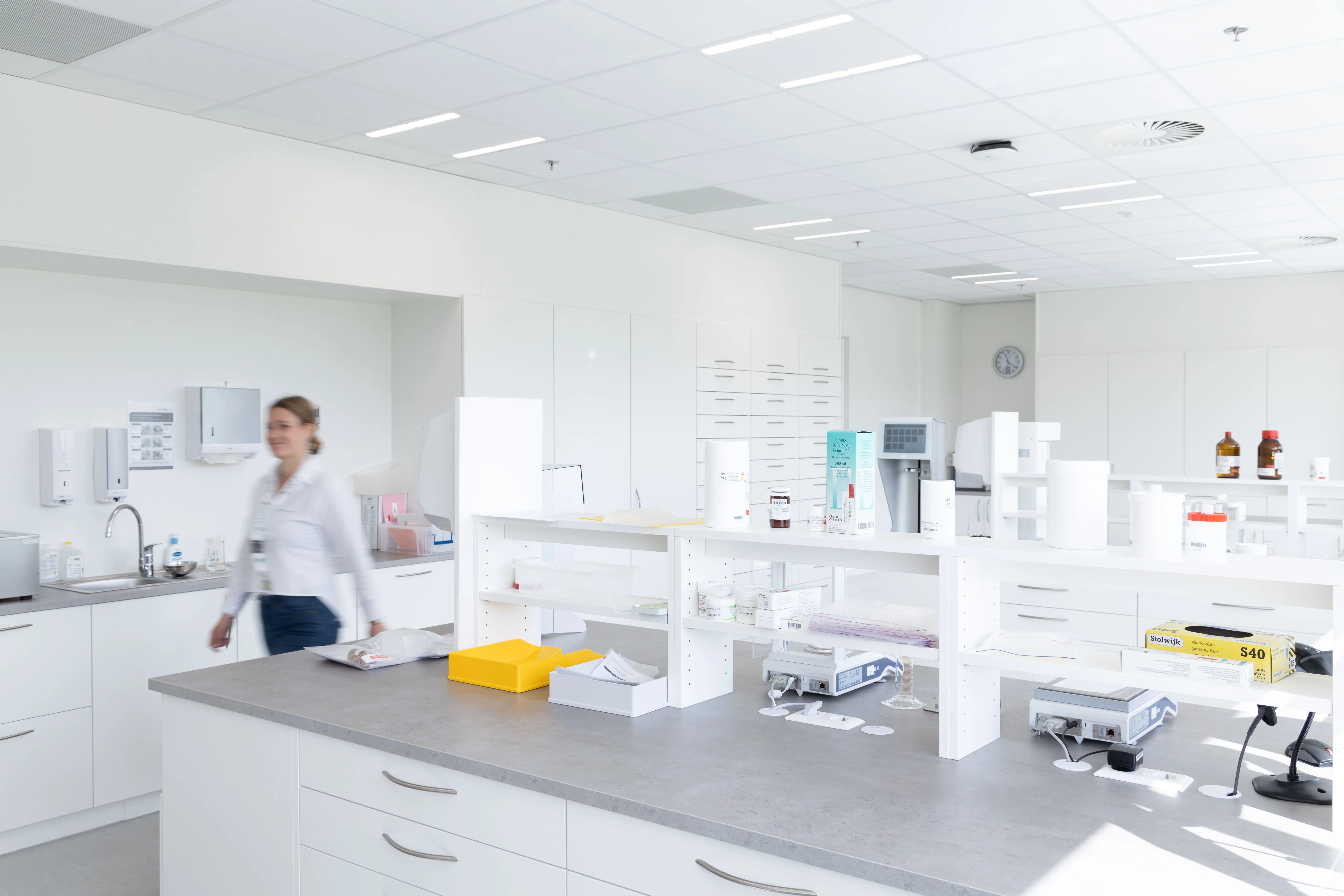 A bright, modern lab at DocMorris with a staff member in motion, showcasing a clean, organized workspace perfect for healthcare innovation.