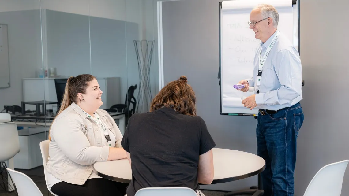Team meeting at PromoFarma by DocMorris, with a friendly vibe and discussions around a table in the office.