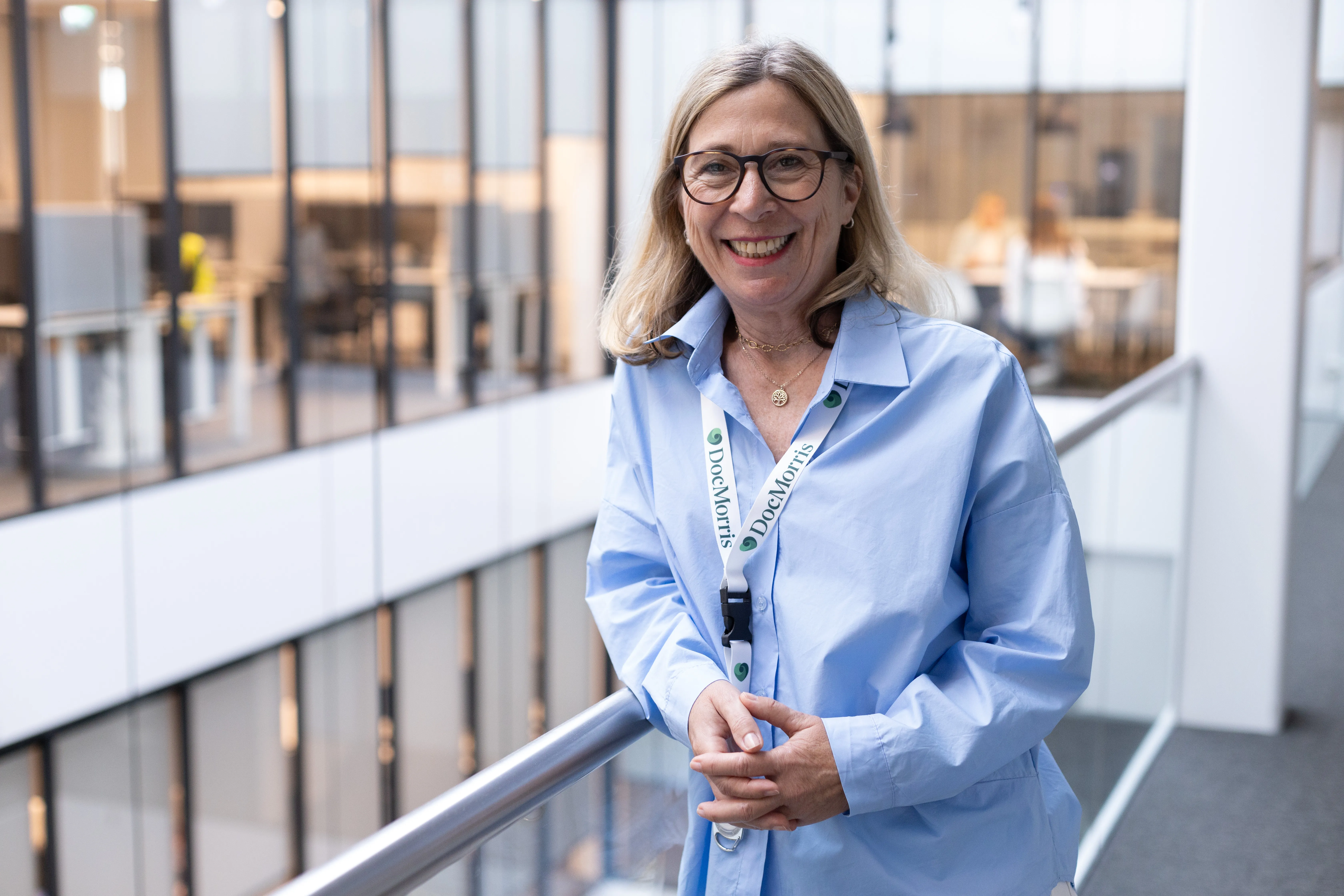 A friendly DocMorris team member smiling in a modern office space, ready to welcome you to the healthcare industry.