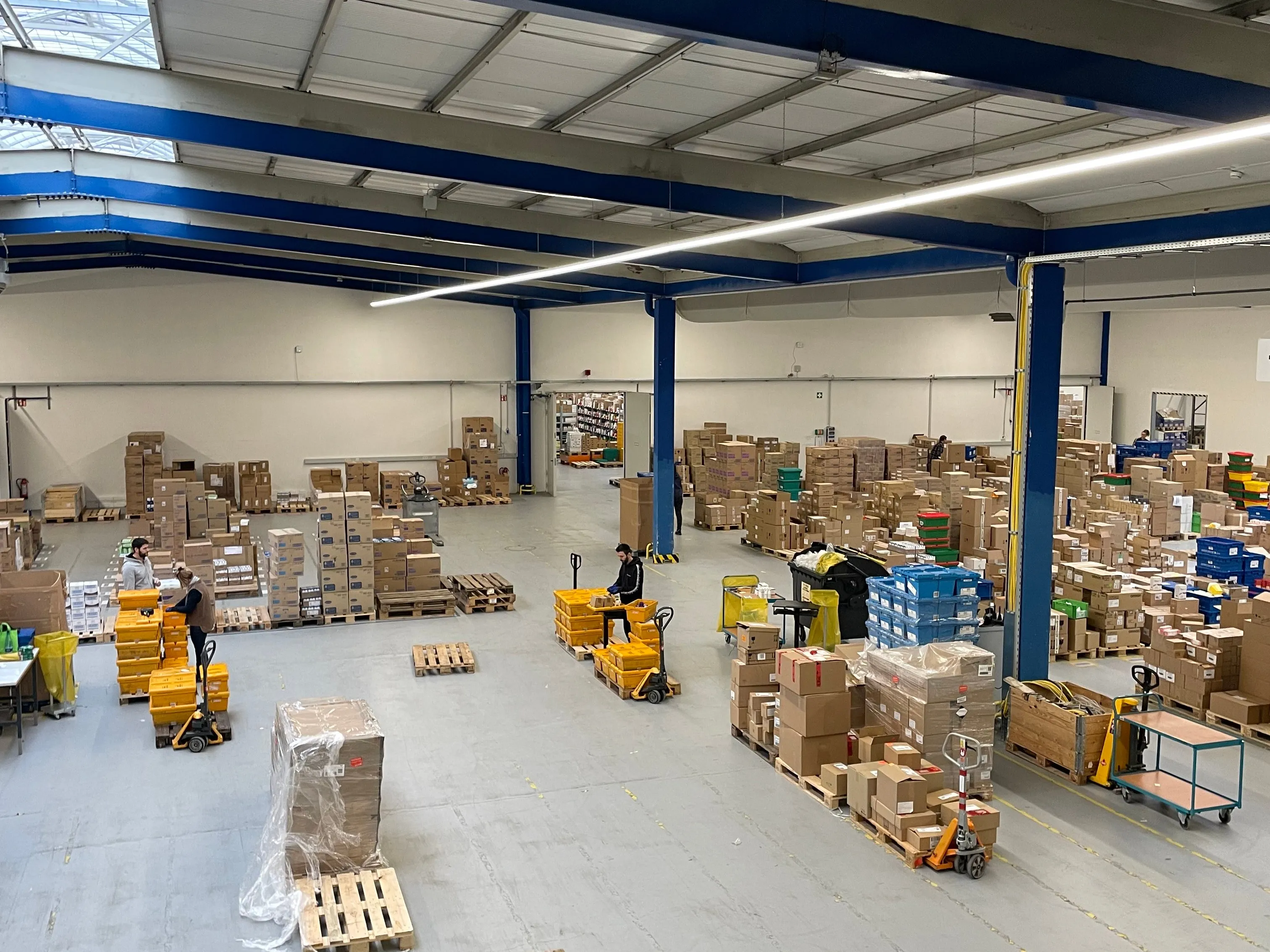 Modern office building of DocMorris with parked cars in front, showcasing a welcoming workplace in healthcare.