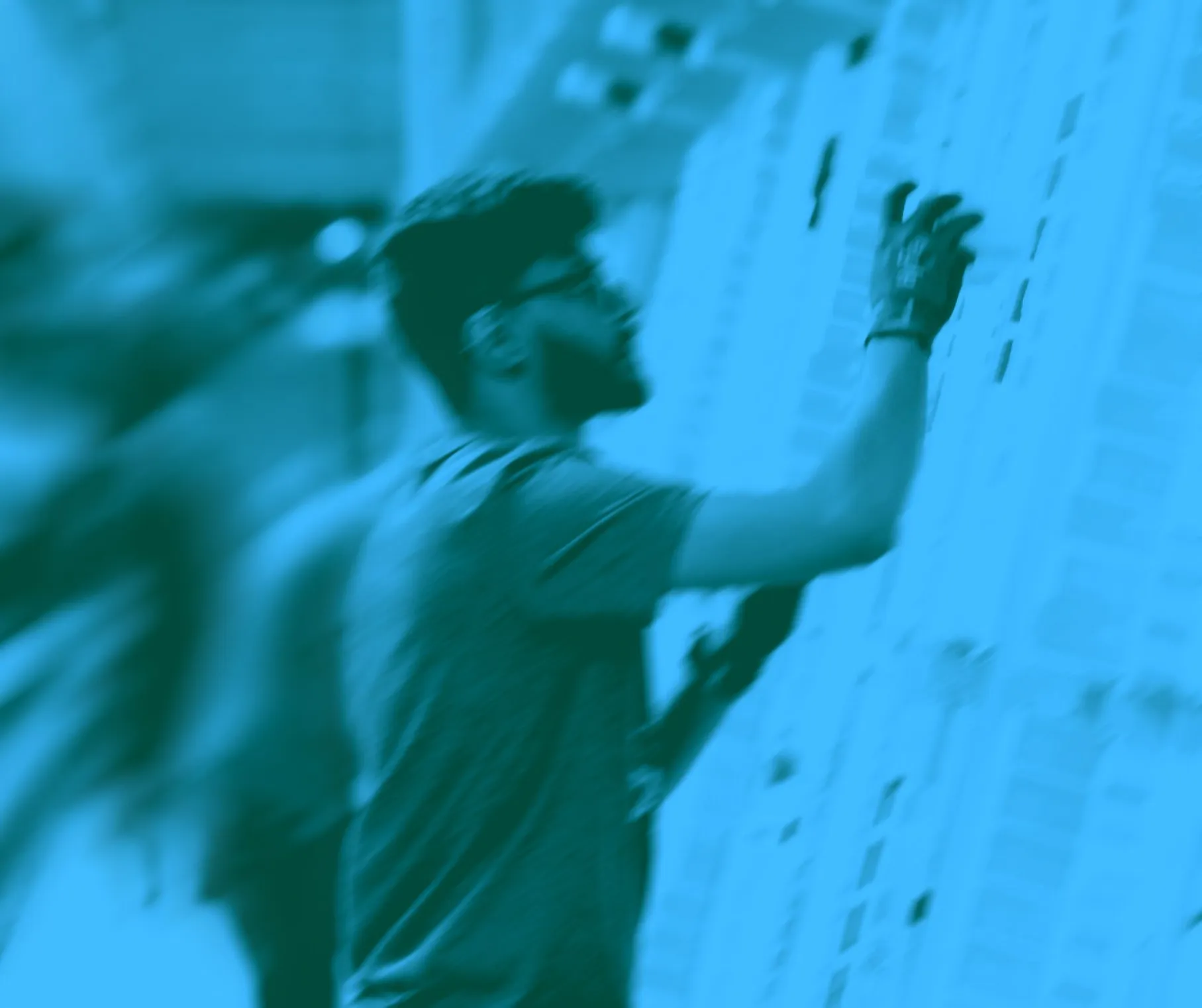 Person checking inventory in a healthcare facility, wearing gloves and focused on shelves.