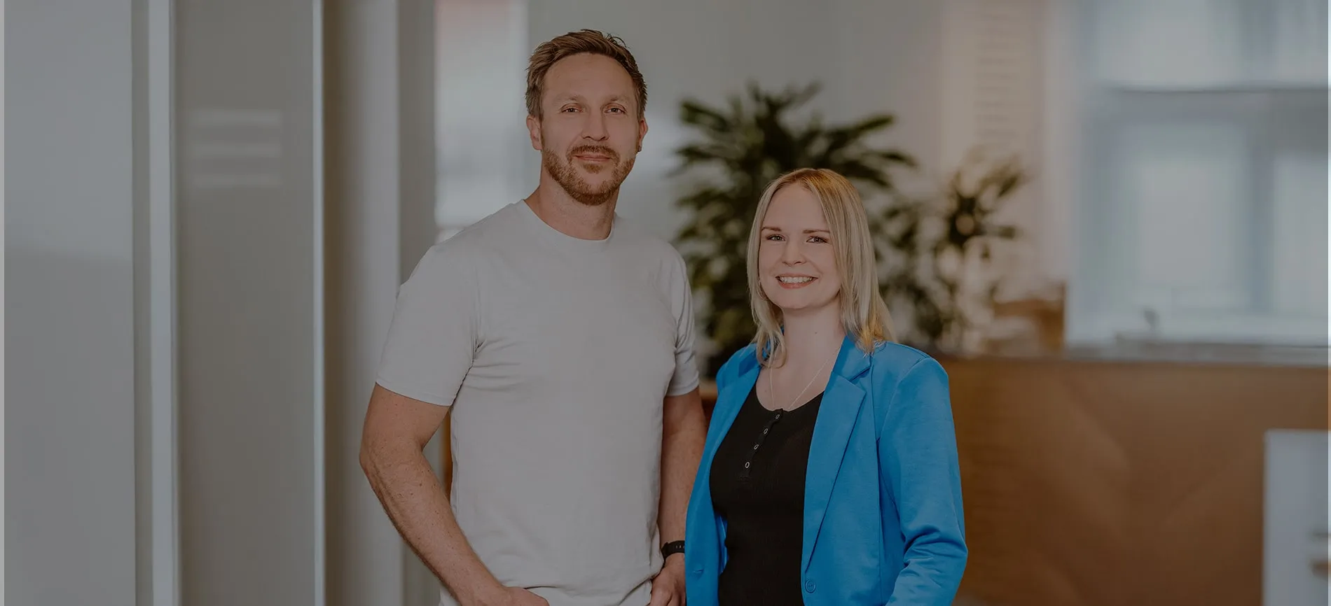 Zwei junge Kolleg:innen von doctari group lächeln freundlich in einem modernen Büro – werde Teil unseres Teams!