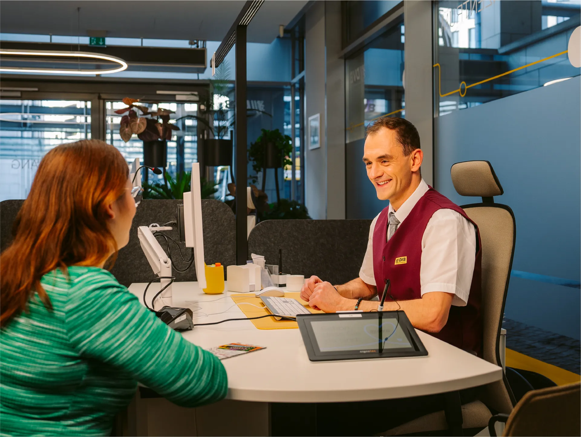 Zwei Männer in einem Büro, die konzentriert auf einen Laptop schauen, neben einem Schaltschrank und einer Ampel.