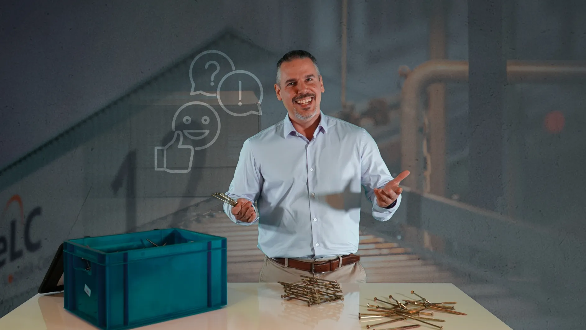 Ein freundlicher Mann steht an einem Tisch mit Arbeitsmaterial, bereit, Dich bei E/D/E im Arbeitsalltag zu unterstützen.