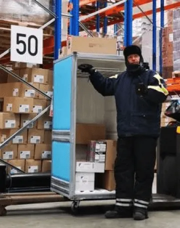 Du siehst einen Lagerarbeiter im Kühlhaus, der Waren für den Einzelhandel von EDEKA Nordwest kommissioniert.