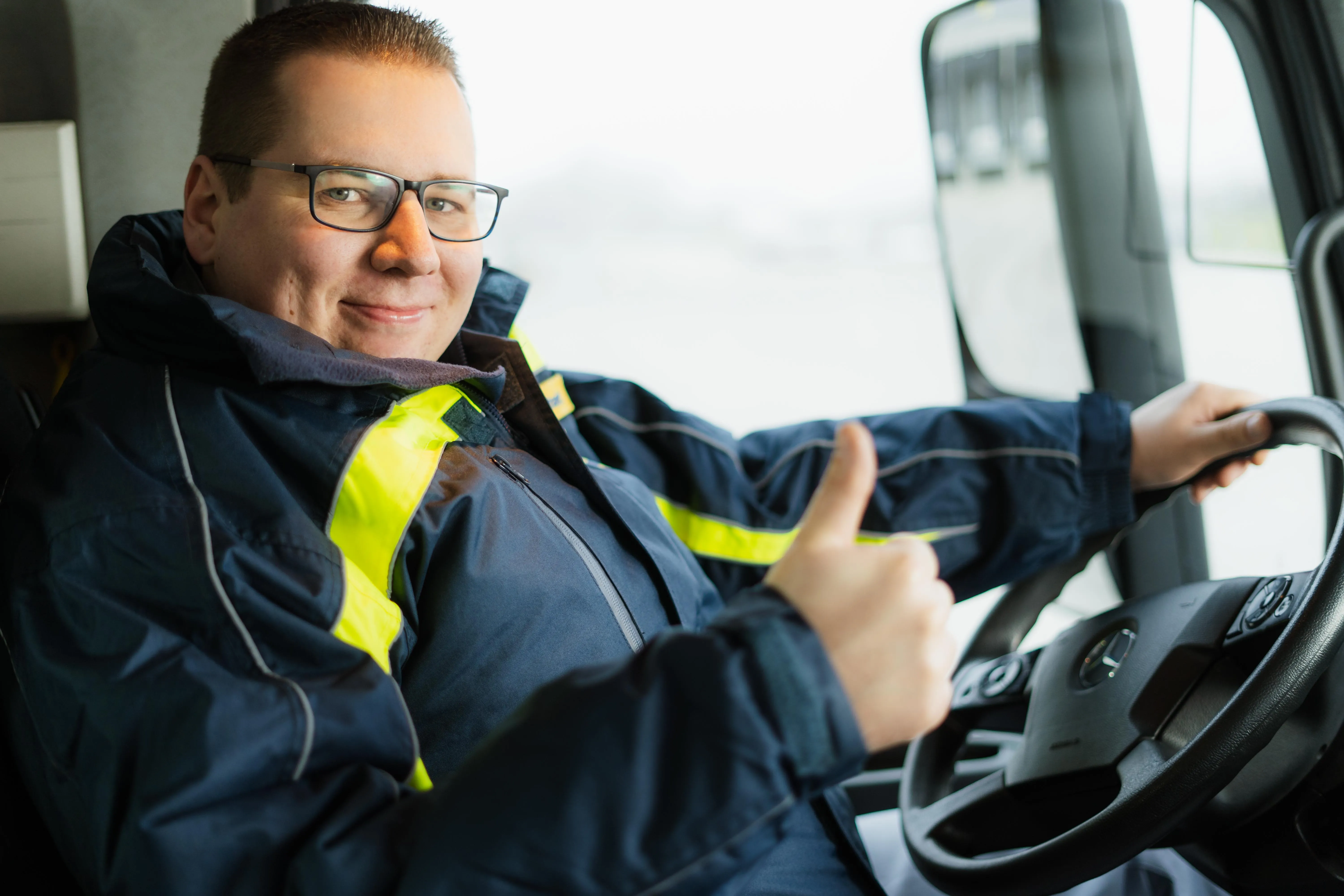 Berufskraftfahrer in LKW lächelt 