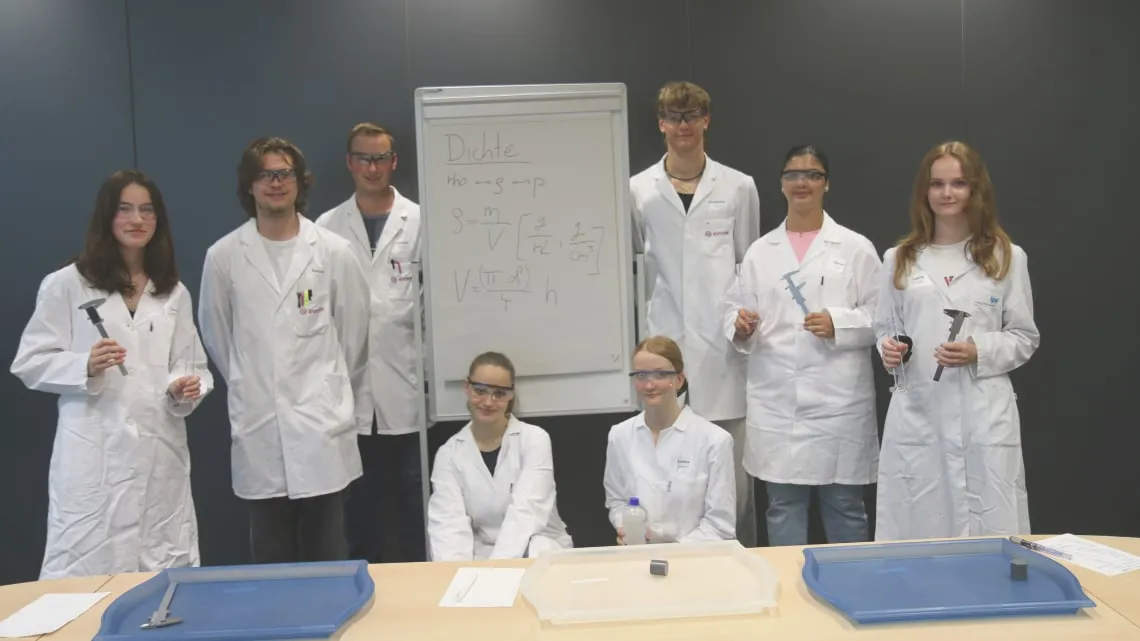 Junge Menschen im Laborkittel arbeiten gemeinsam an einem Experiment bei Evonik – starte auch Du Deine Karriere hier!