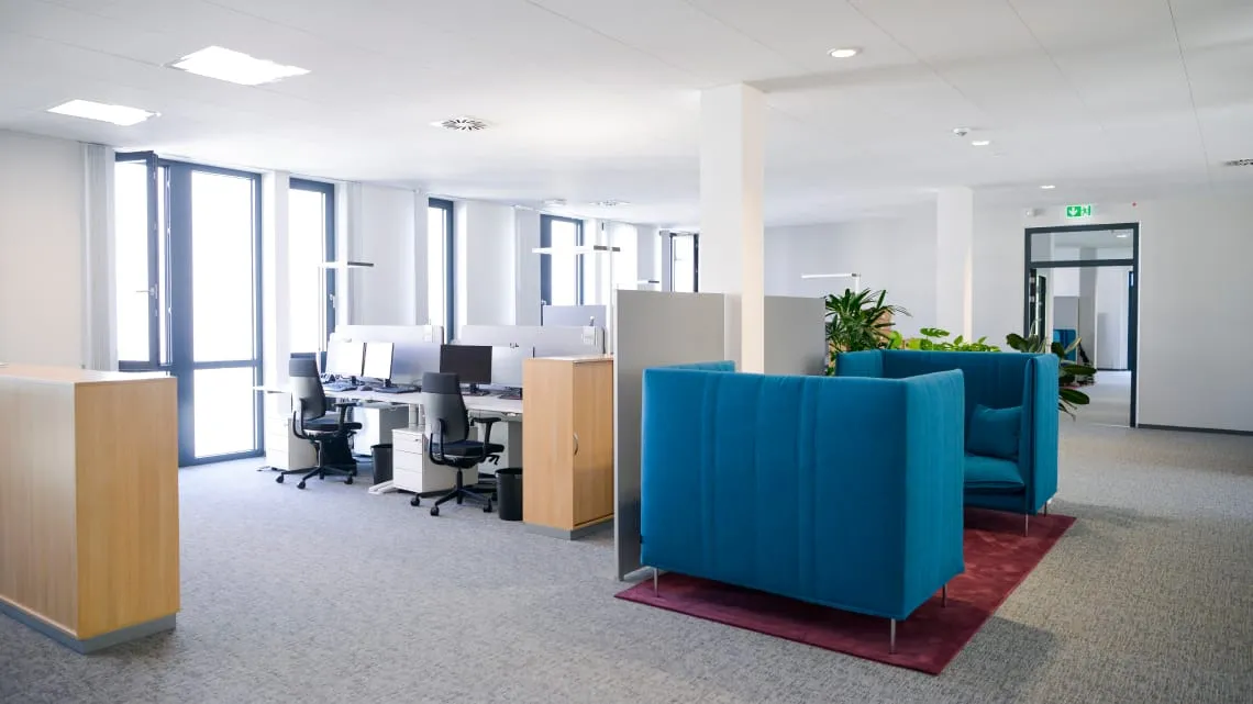 Modernes, helles Büro bei Evonik mit offenen Arbeitsplätzen und gemütlichen Sitzbereichen für Teamarbeit.