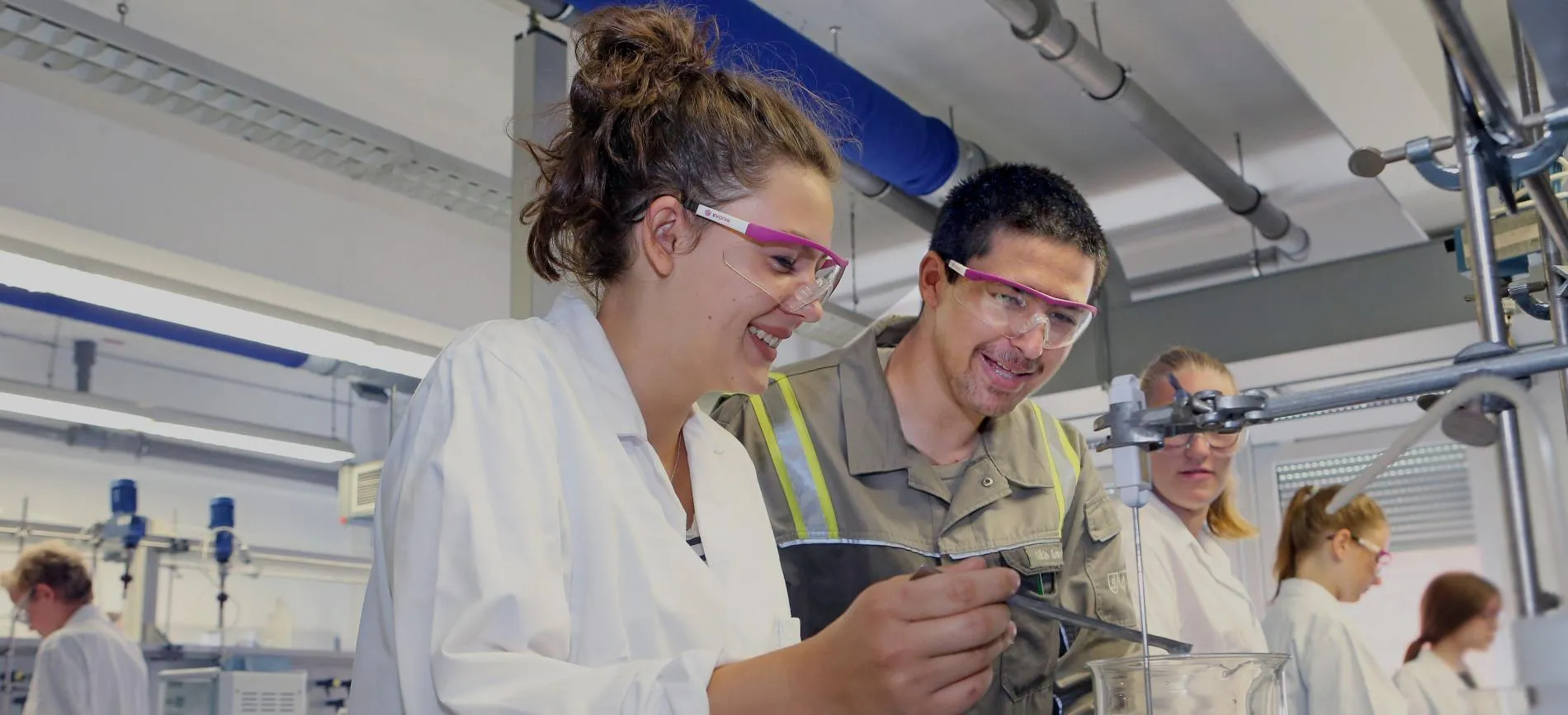 Junge Menschen arbeiten gemeinsam im Labor von Evonik und führen ein Experiment durch – entdecke Deine Möglichkeiten im Team.
