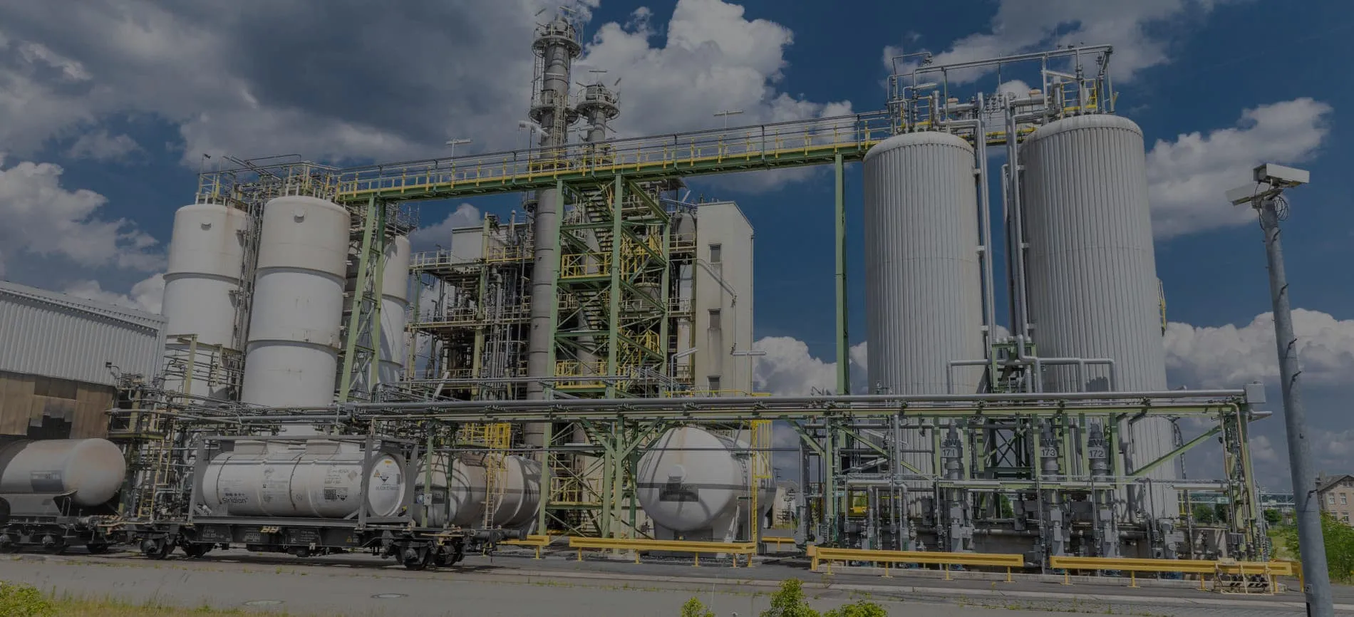 Industrielle Anlage mit großen Tanks und Rohrleitungen unter blauem Himmel. Ideal für Karrierechancen in der Energie- und Versorgungsbranche.