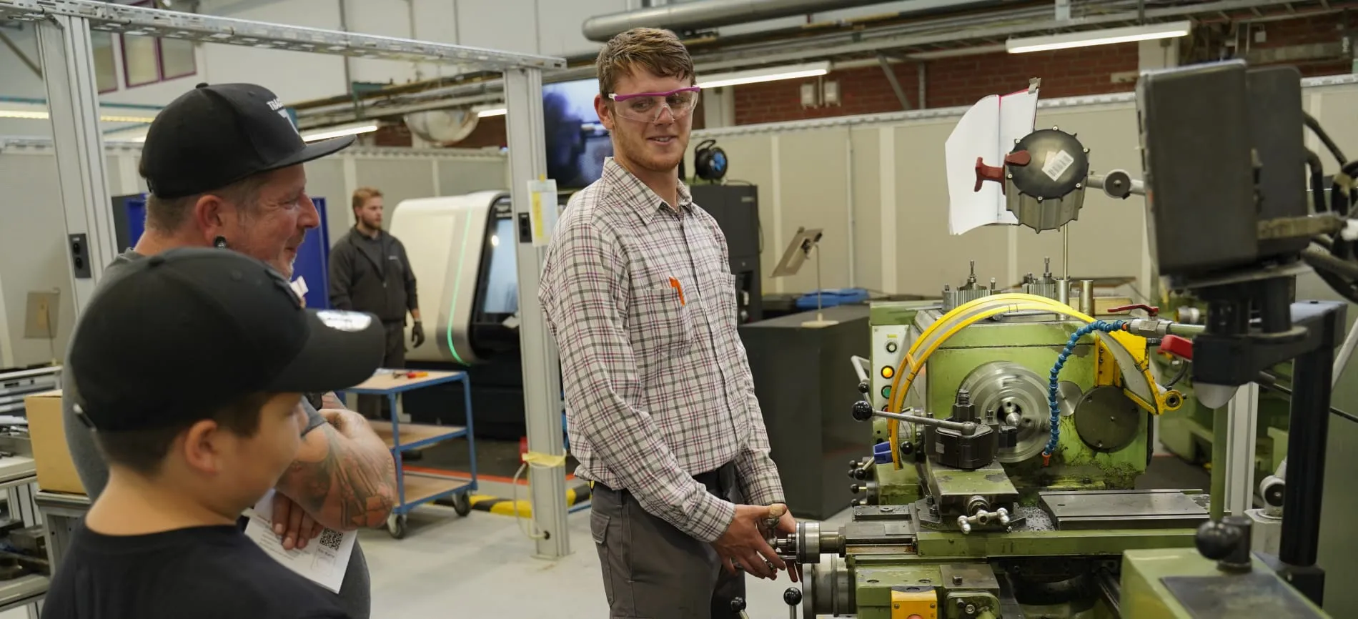 Ein Mitarbeiter zeigt Besuchern eine industrielle Maschine in einer Produktionsanlage von Evonik.