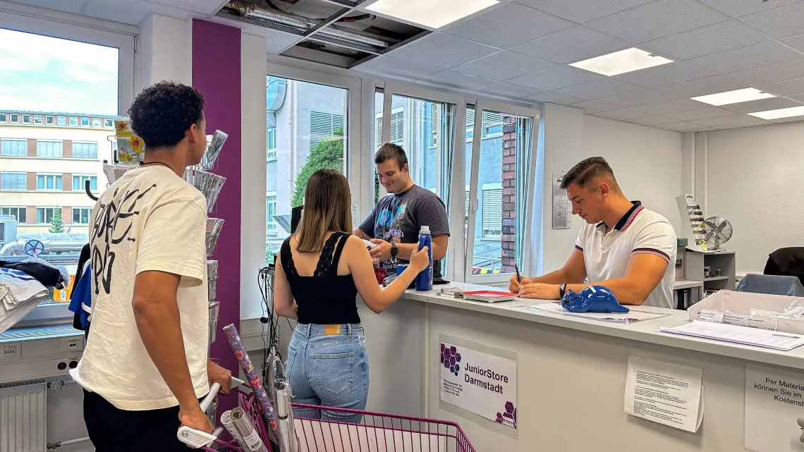 Drei junge Erwachsene werden an einem Empfang im JuniorStore beraten – hier kannst du bei Evonik durchstarten.