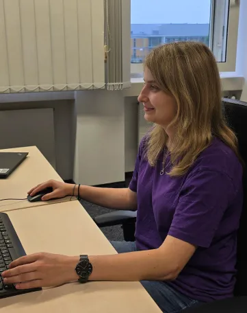 Junge Frau arbeitet konzentriert am Computer in einem modernen Büro bei Evonik im Bereich Energie und Versorgung.