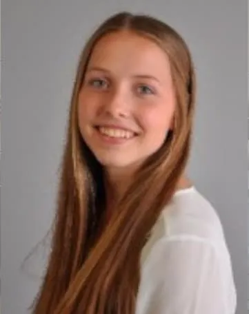 Junge Frau mit langen, braunen Haaren lächelt freundlich in die Kamera, ideal für Deinen Einstieg bei Evonik.
