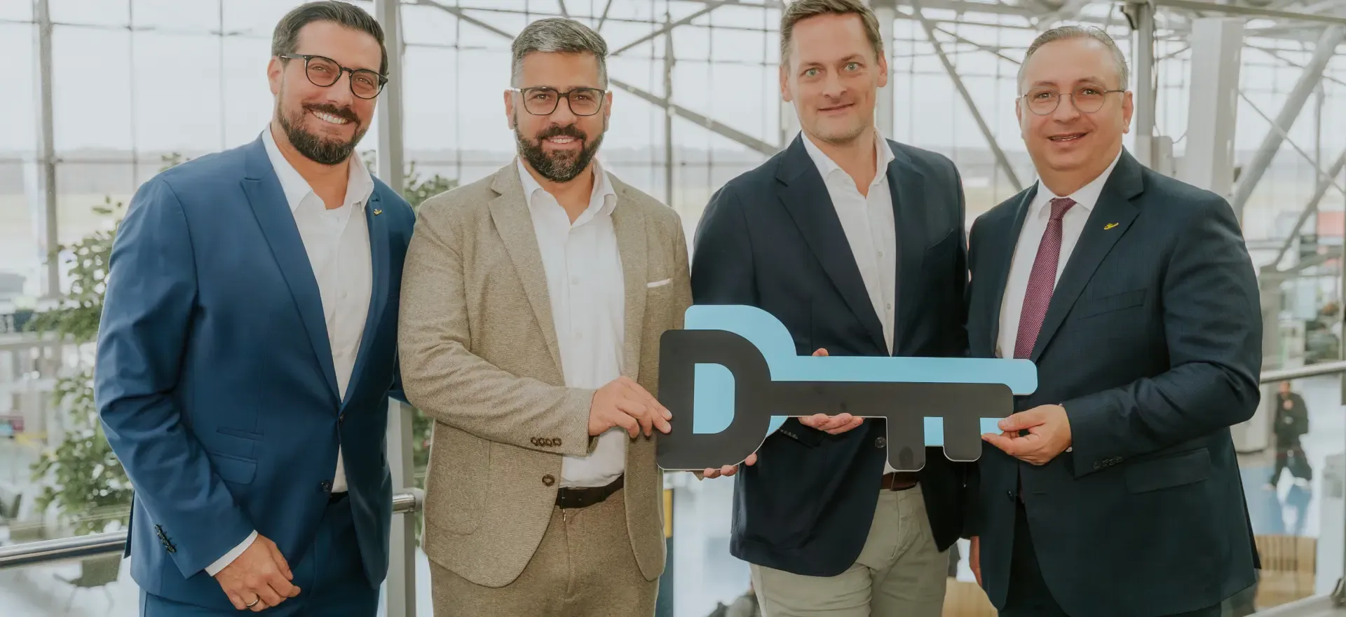 Eine Gruppe von acht FIEGE-Mitarbeitern steht im Kreis und legt ihre Hände übereinander, symbolisiert Teamarbeit in der Logistikbranche.