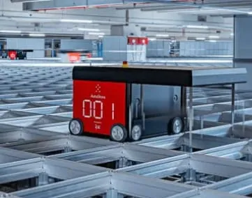 Ein autonomer Roboter transportiert Waren in einem modernen Logistikzentrum von FIEGE.