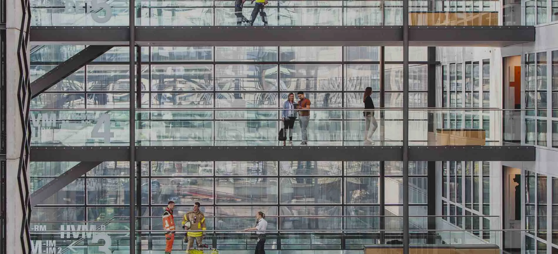 Modernes Bürogebäude bei Fraport AG, in dem Mitarbeitende in verschiedenen Bereichen zusammenarbeiten und sich austauschen.