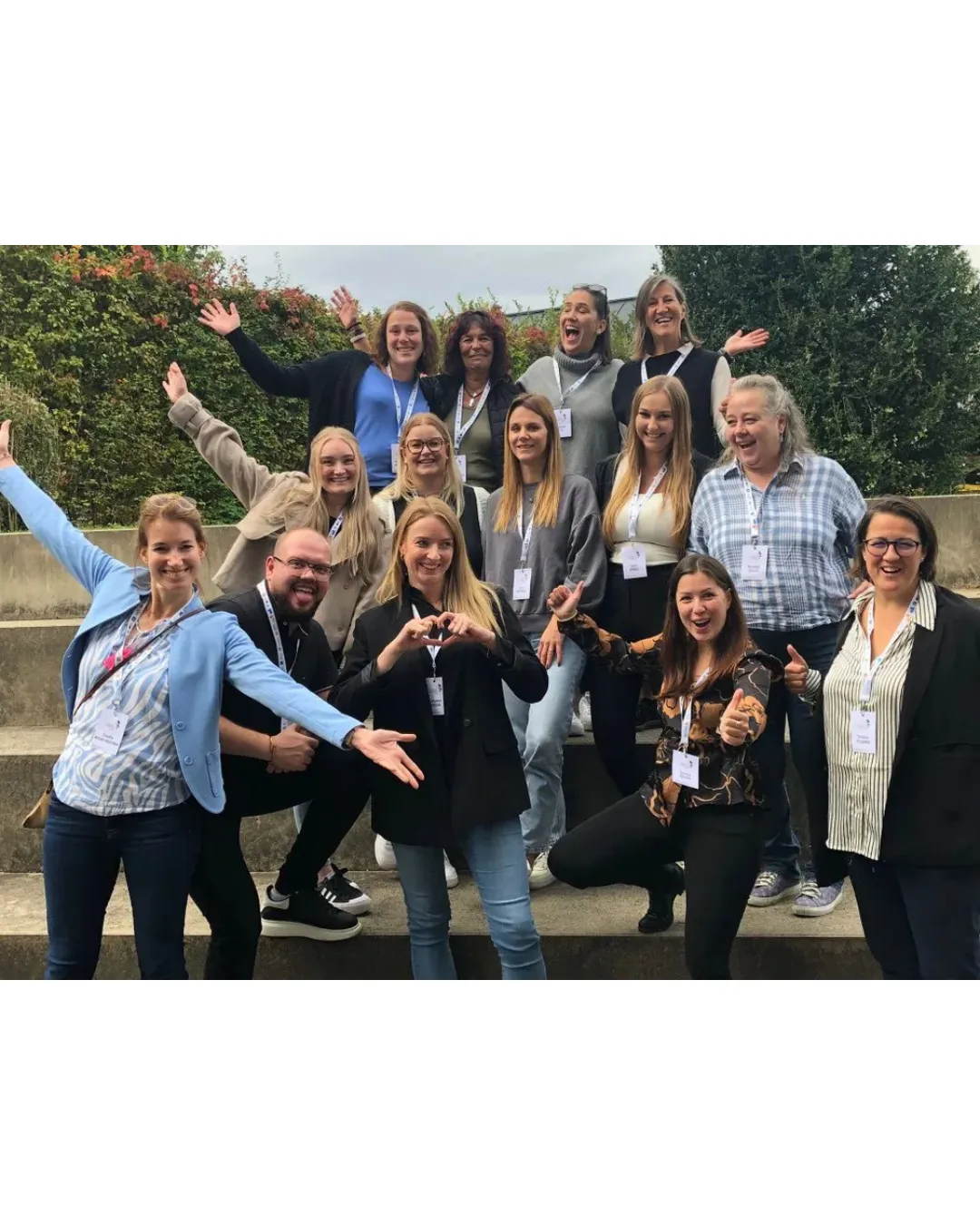 Ein fröhliches Team der Frauenthal Handel Gruppe posiert gemeinsam draußen und zeigt Begeisterung für den Einzelhandel.