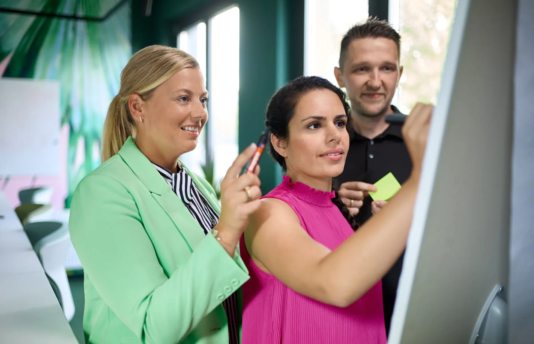Team am Whiteboard bei kreativer Arbeitssession im Büro von Fressnapf Holding SE.