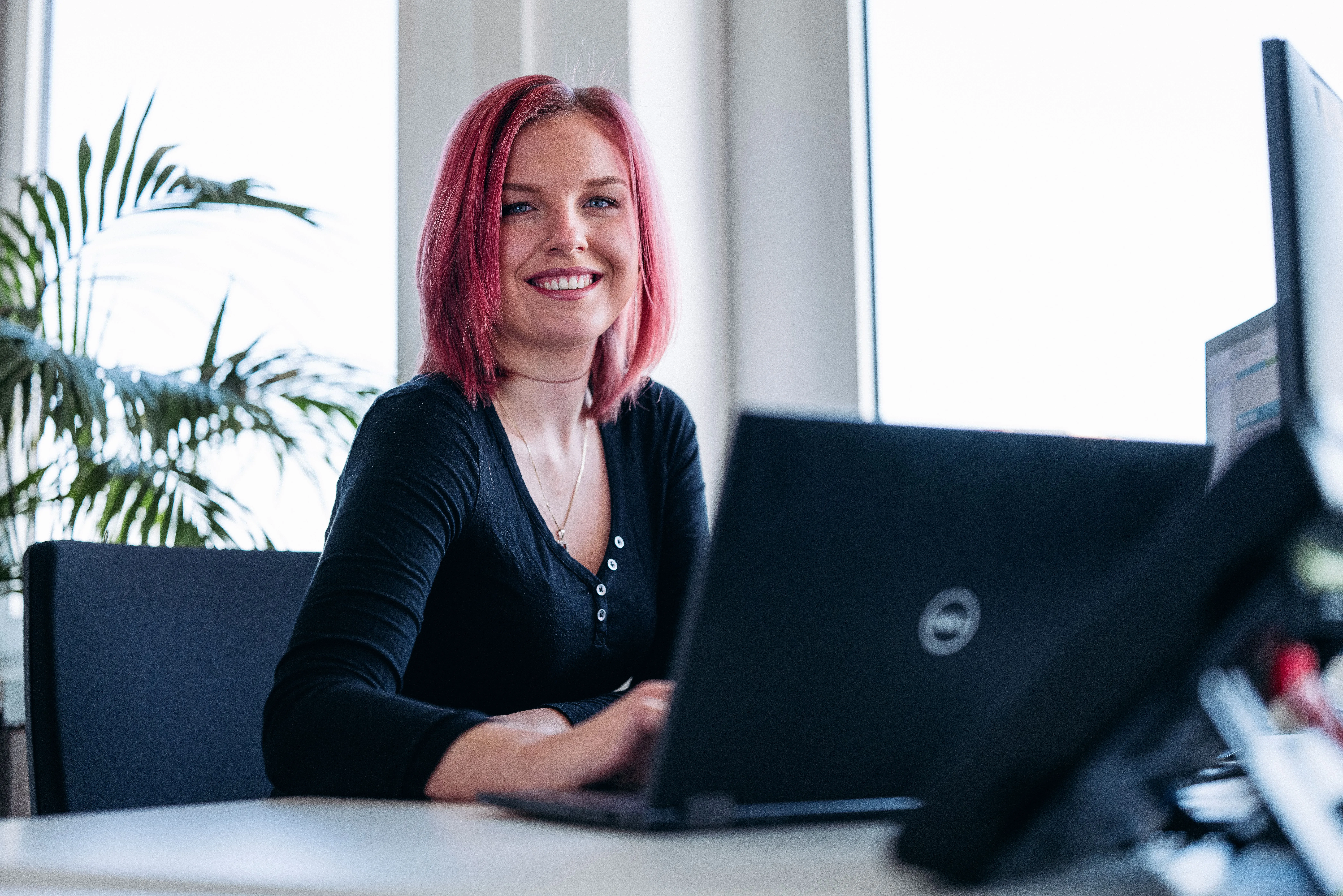 Laptop mit bunten Aufklebern auf einem Tisch, daneben steht eine rote Tasse. Perfekt für kreative Arbeitsumgebungen bei GTÜ.