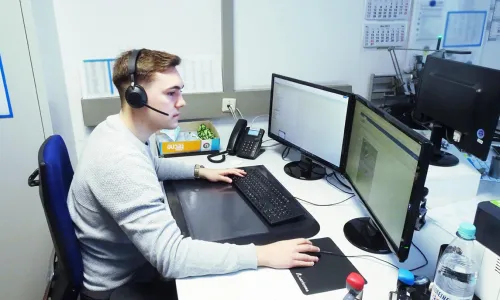 Mann mit Headset am Computer