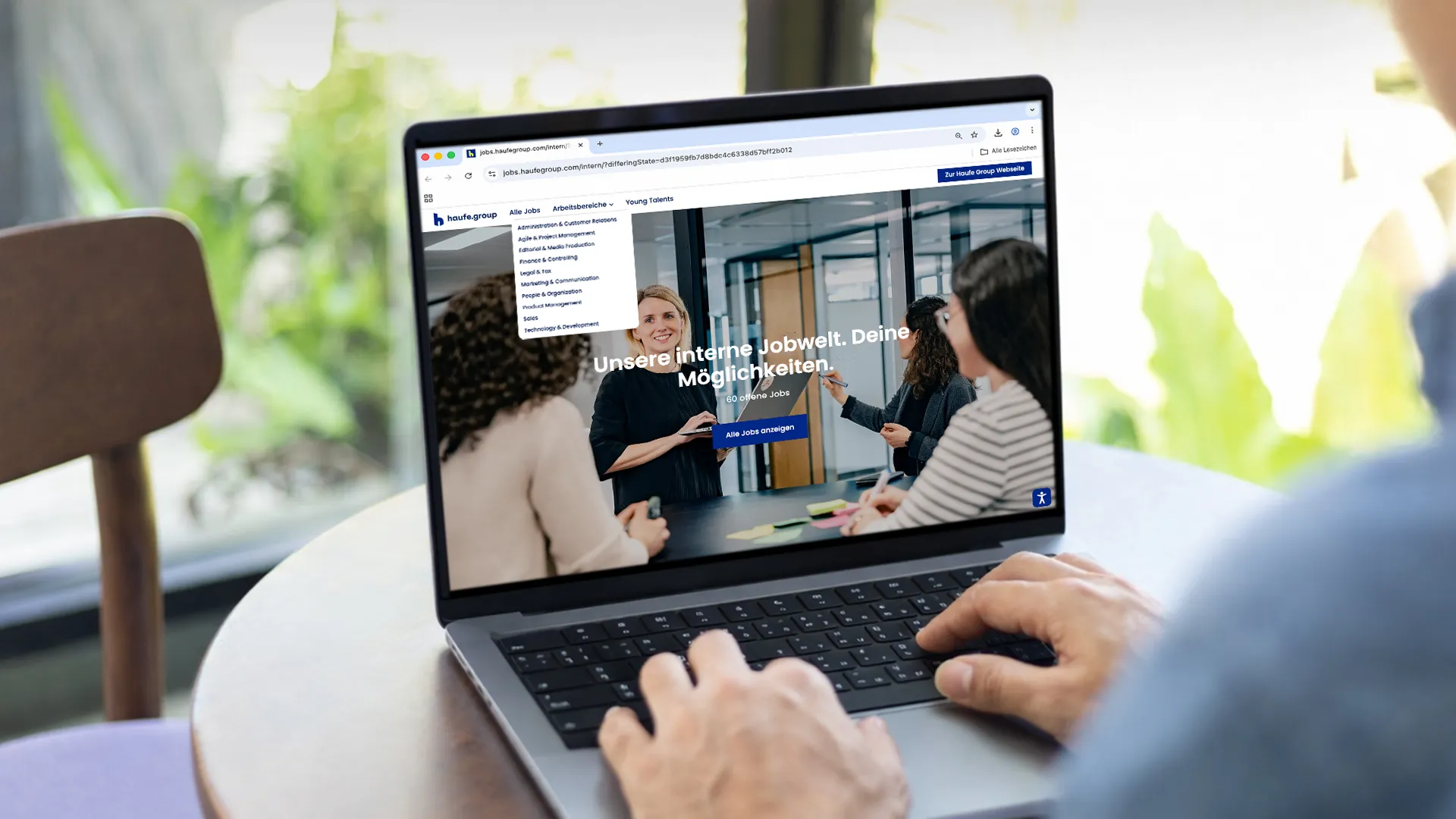 Person recherchiert auf einem Laptop die Karriereseite der Haufe-Group