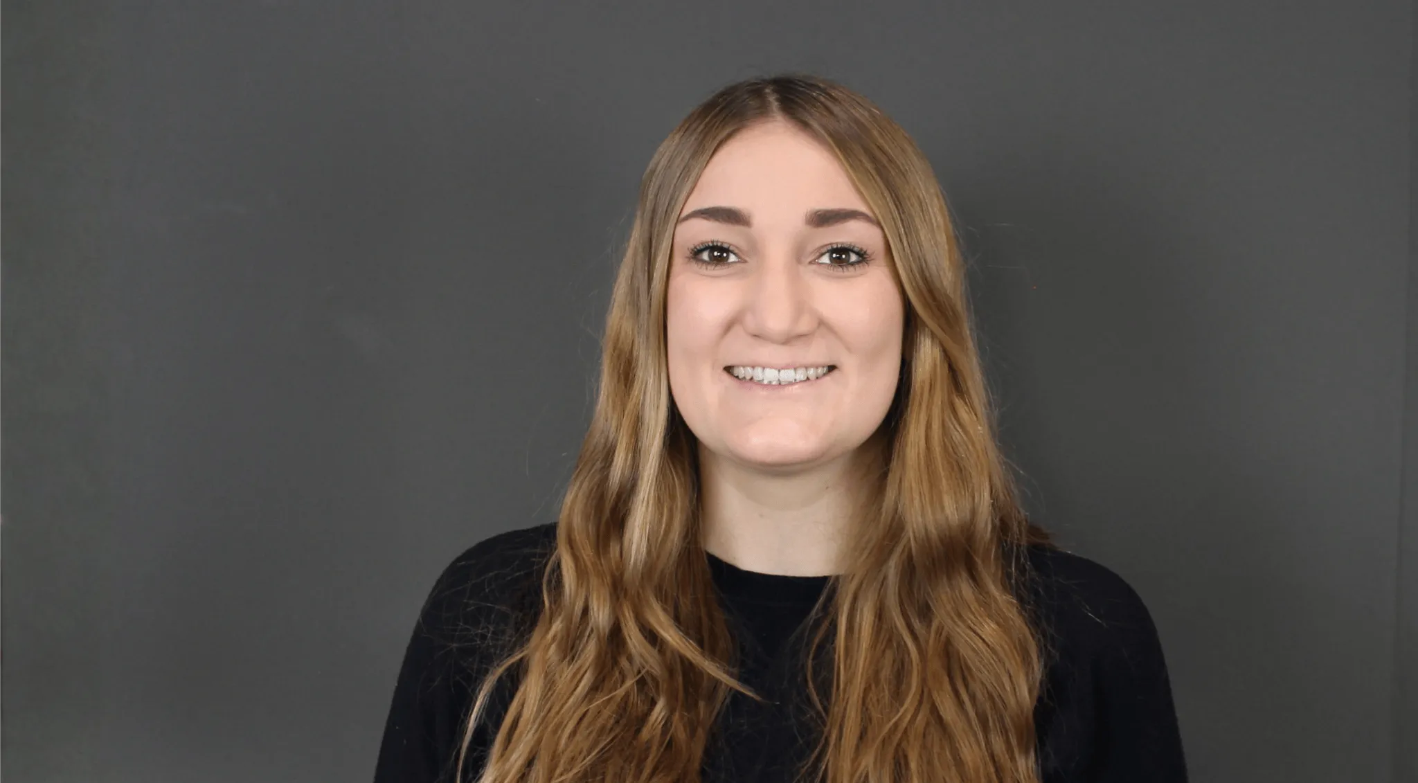 Eine lächelnde Frau sieht in die Kamera