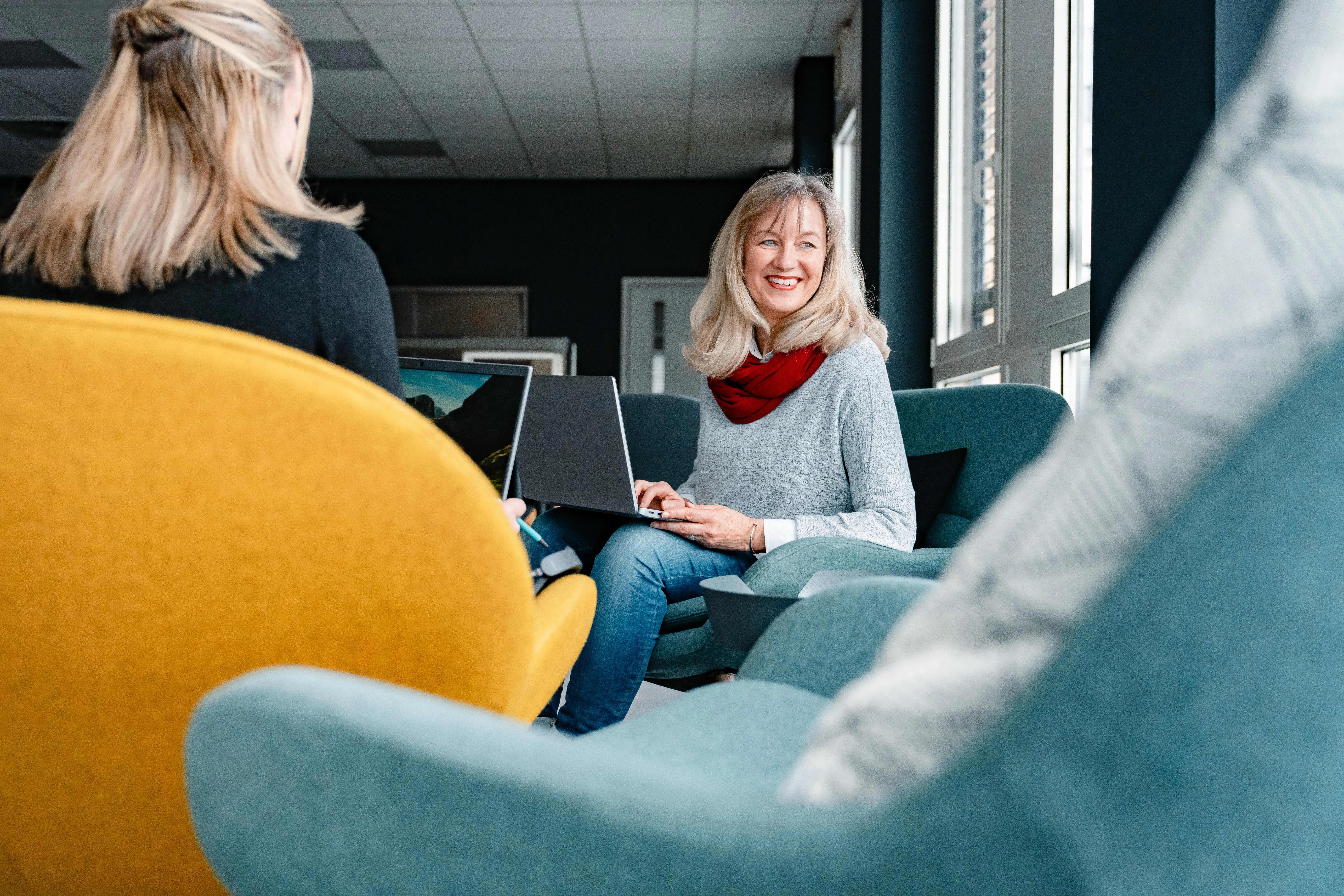 Zwei Personen in einem modernen Büro arbeiten konzentriert an einem Computerbildschirm.