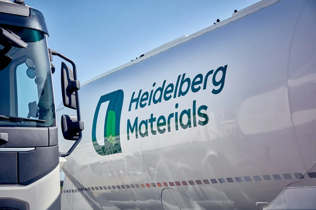 Ein Lkw mit dem Logo von Heidelberg Materials auf einem weißen Tank, der in der Bauindustrie tätig ist.