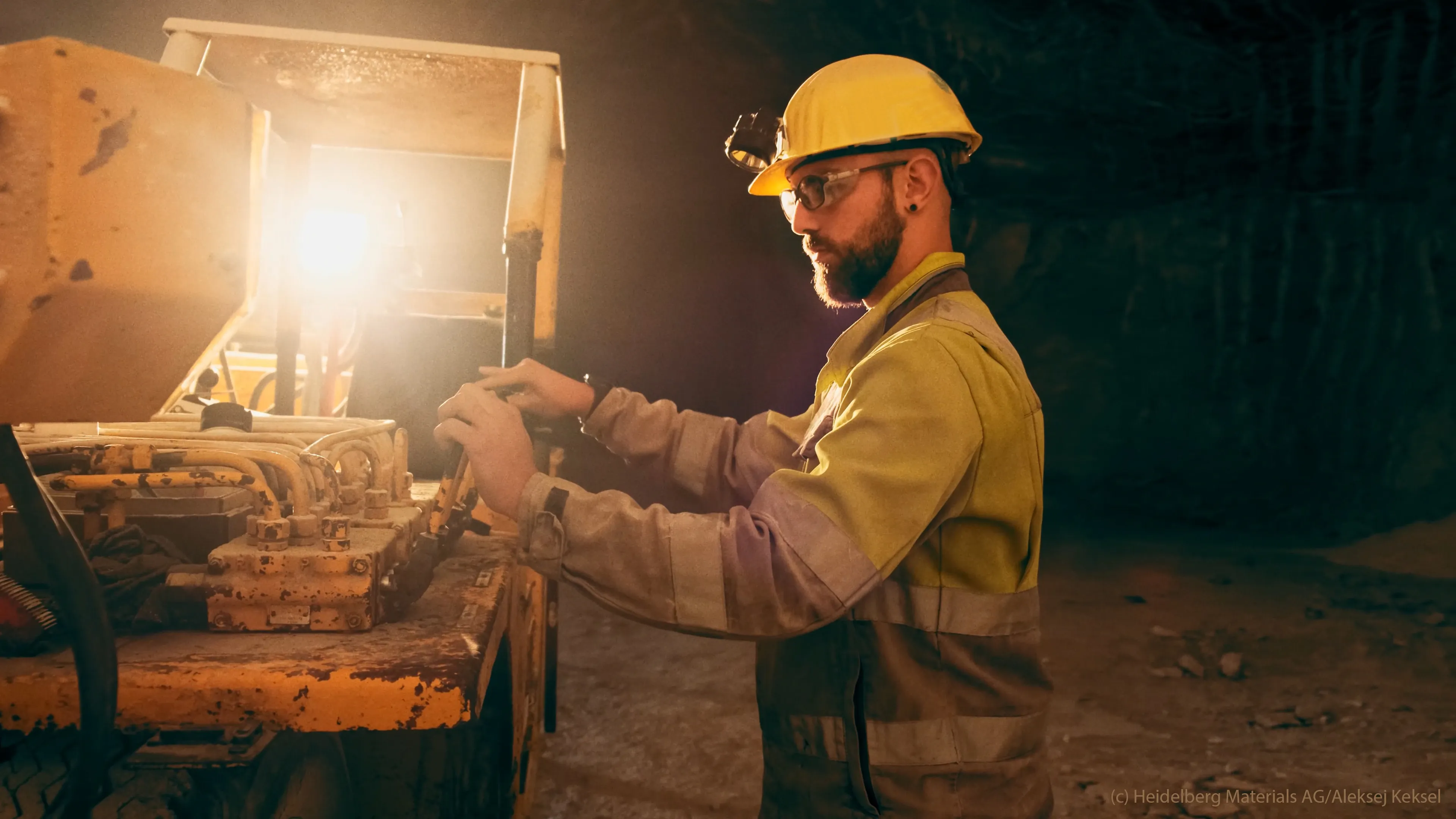 Ein Bauarbeiter in Schutzkleidung bedient eine Maschine in einem Tunnel für Heidelberg Materials GmbH.