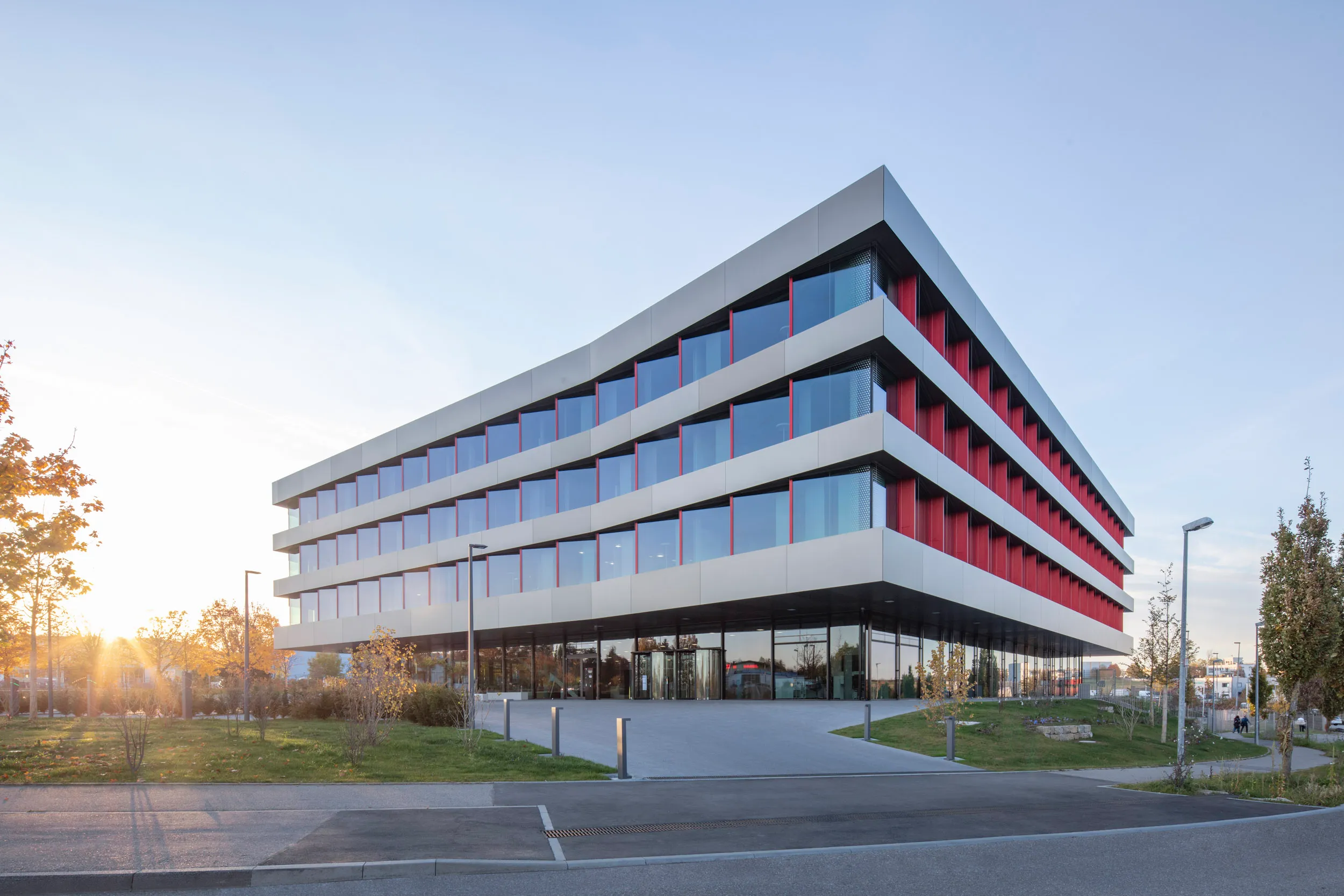 Industriegebäude von HELU KABEL GmbH mit grauer Fassade und roten Fenstern, ideal für Deine Karriere im Bereich Fertigung.