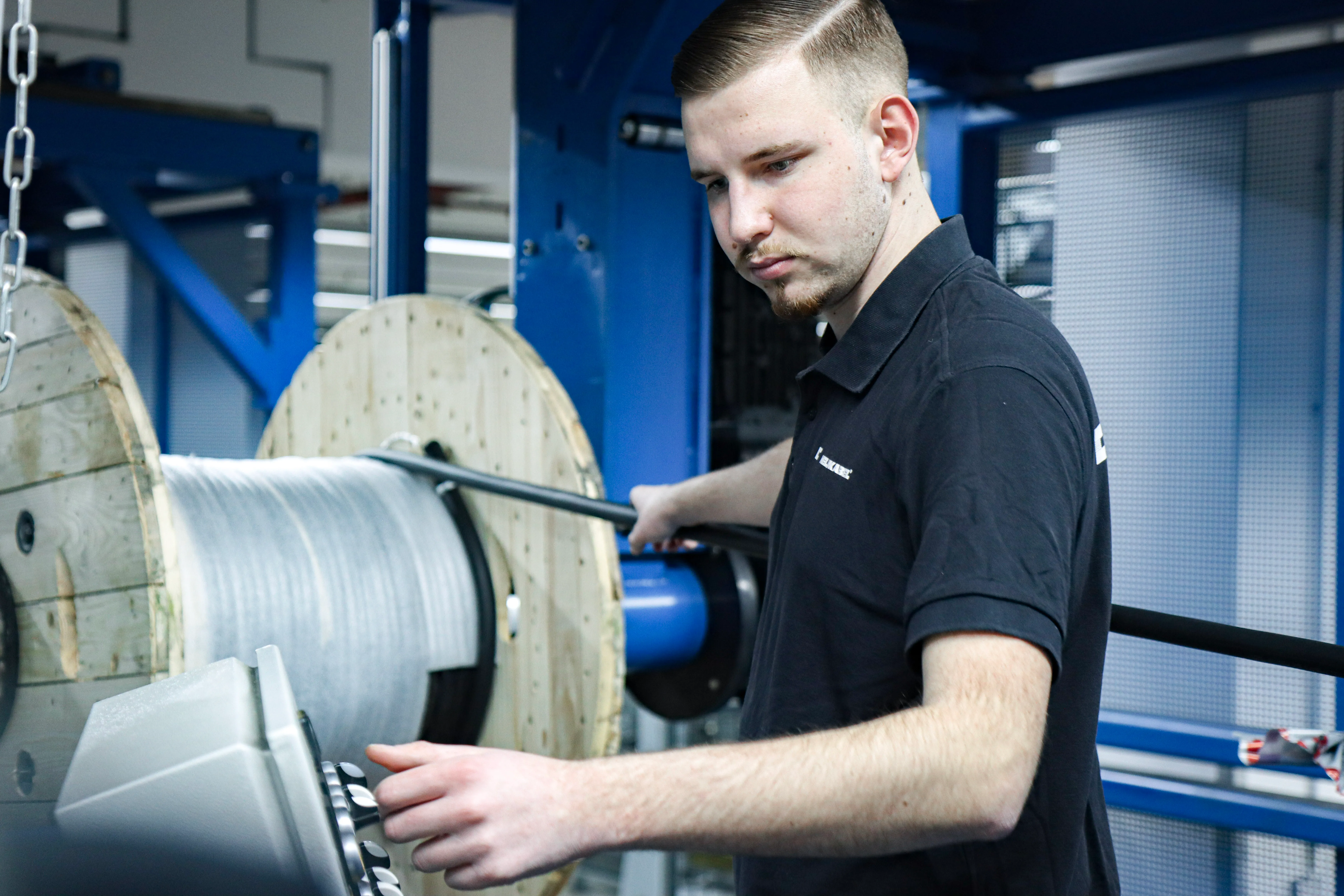 Industriegebäude von HELU KABEL GmbH mit grauer Fassade und roten Fenstern, ideal für Deine Karriere im Bereich Fertigung.