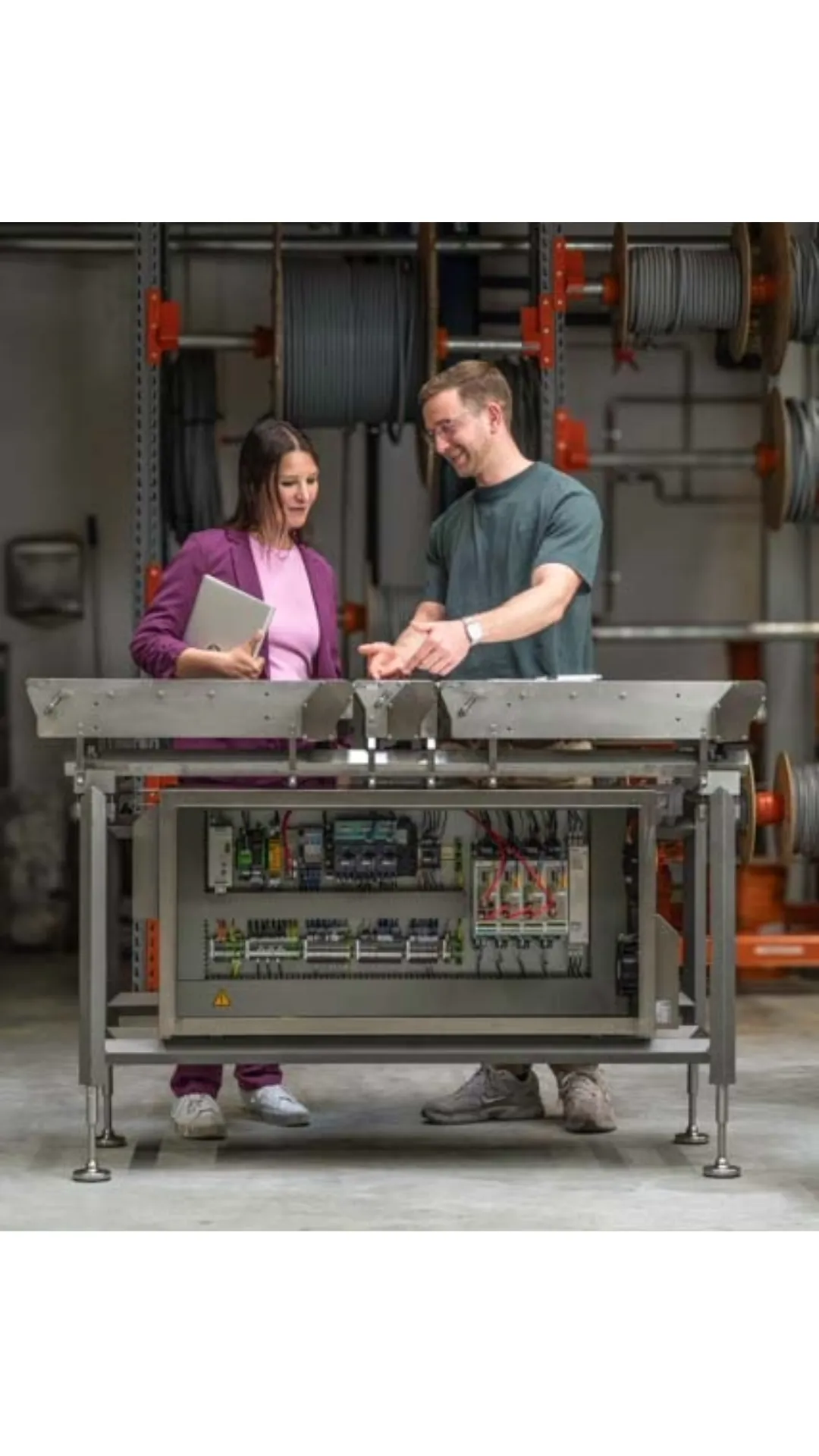Zwei Kollegen besprechen Produktionsunterlagen an einem Förderband in der Lebensmittelindustrie.