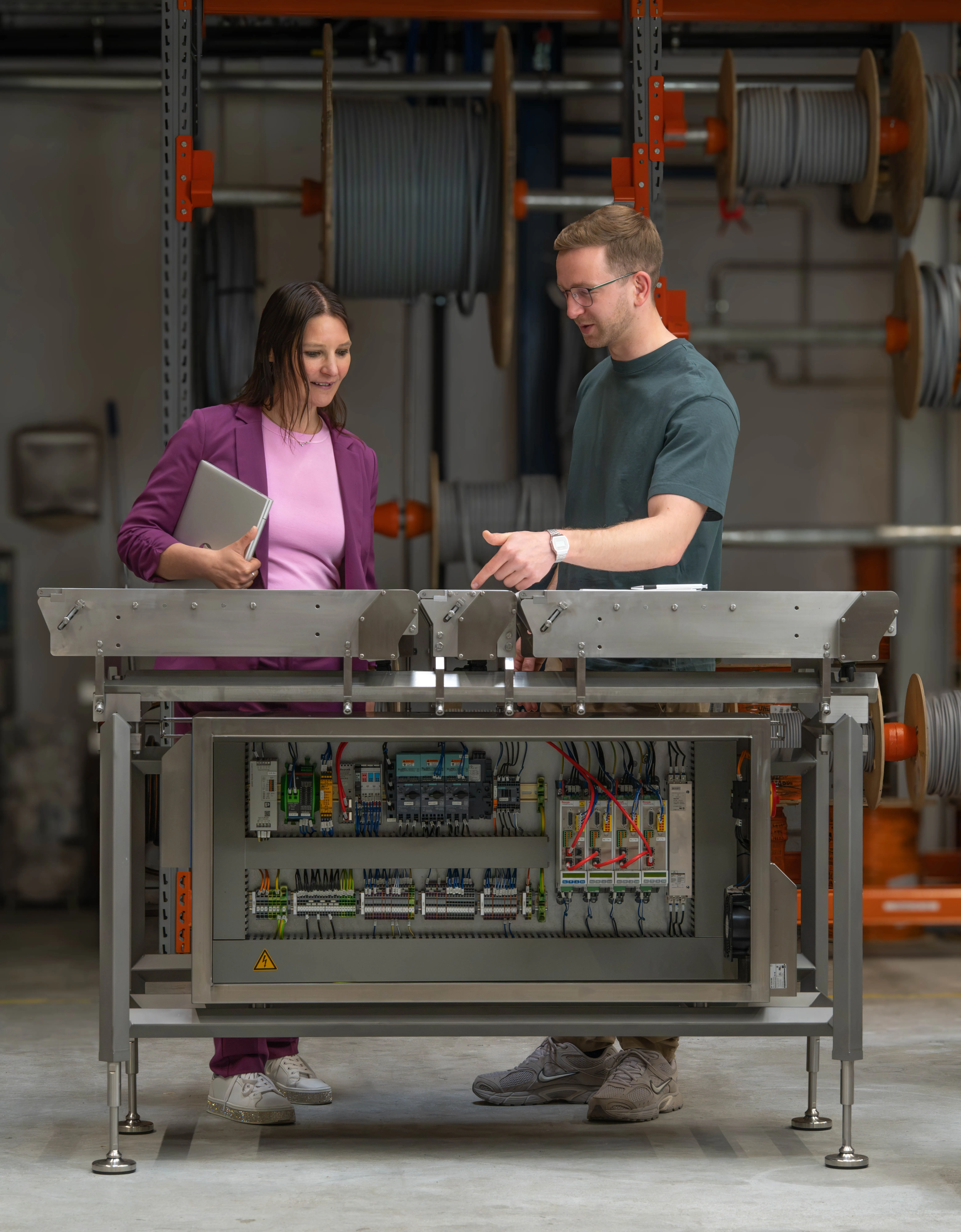 Zwei Kollegen besprechen Produktionsunterlagen an einem Förderband in der Lebensmittelindustrie.
