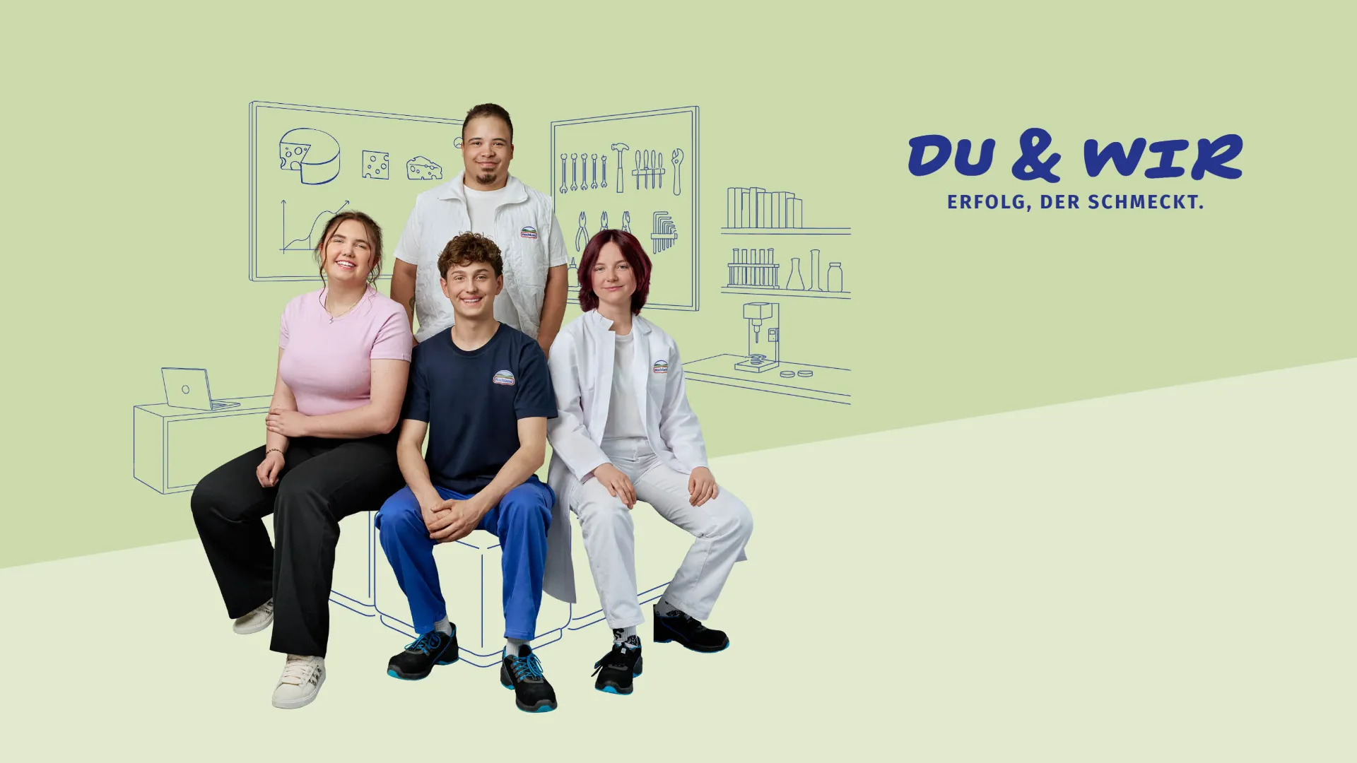 Vier junge Mitarbeitende von Hochland lächeln gemeinsam für ein Teamfoto im Studio, zwei tragen Arbeitskleidung.