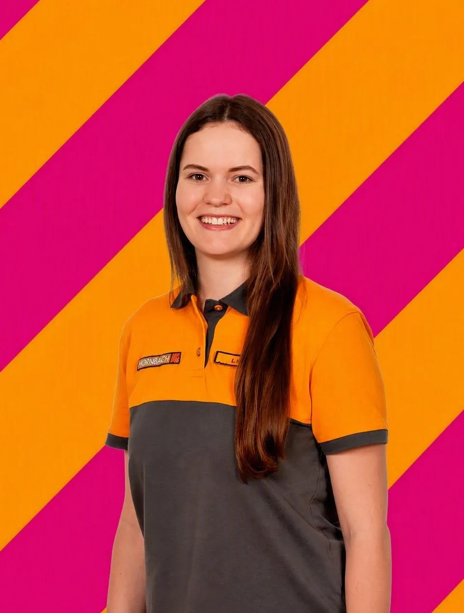 Die lächelnde Mitarbeiterin Lena Haas von HORNBACH in orange-grauer Uniform vor einem bunten Hintergrund.